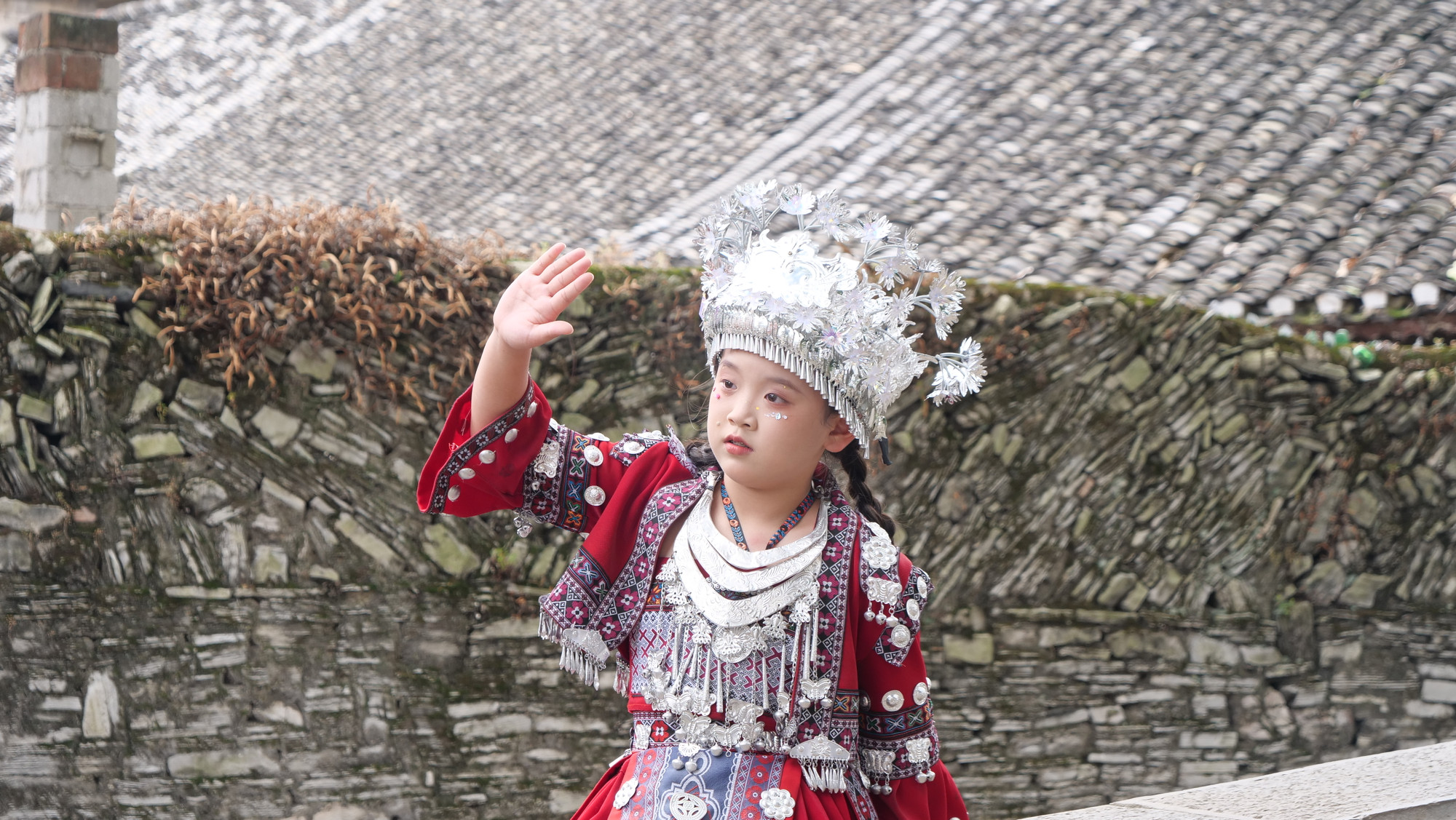 Bé gái tạo dáng chụp ảnh trong trang phục dân tộc truyền thống.