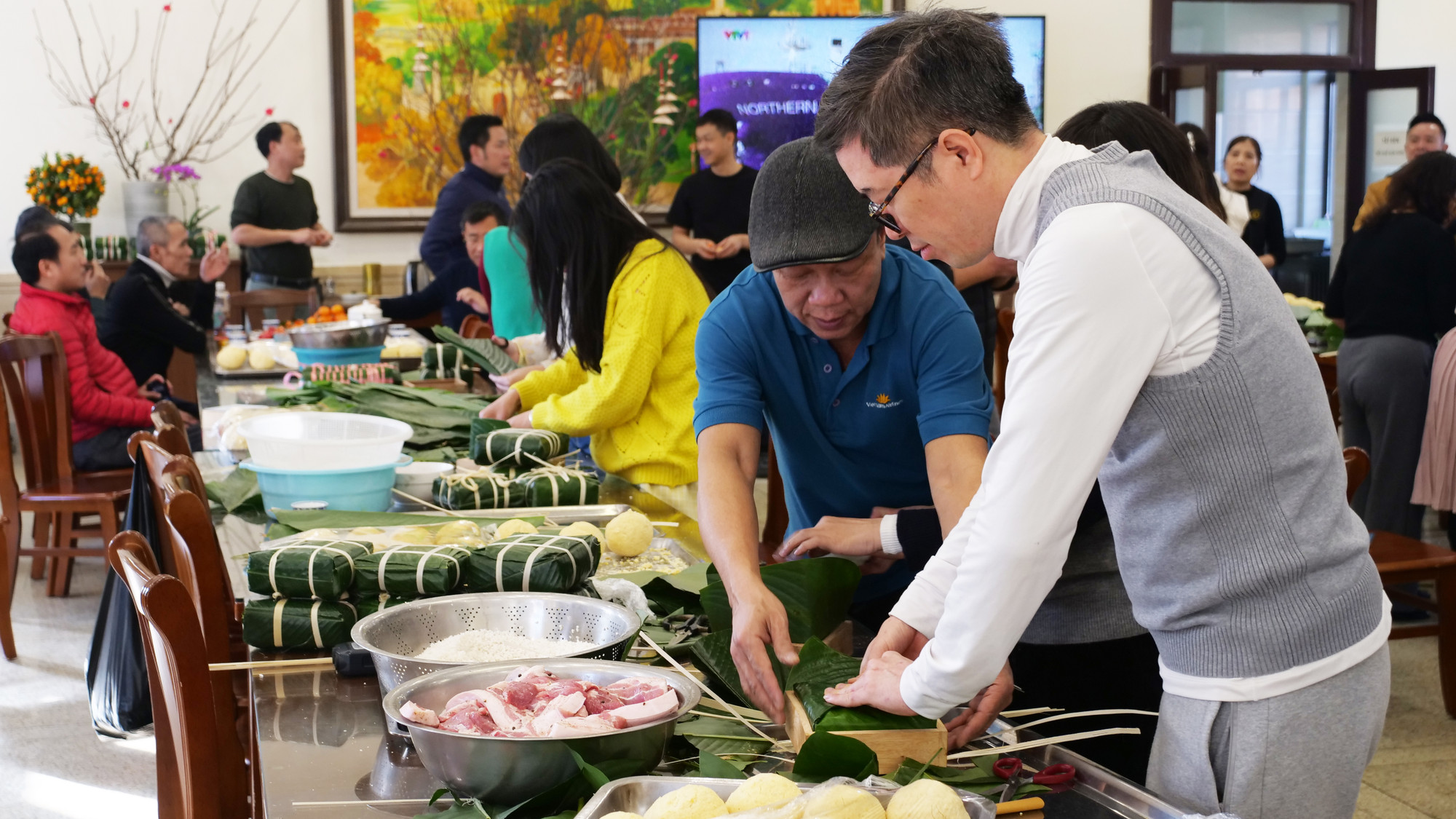 Hỗ trợ nhau hoàn thành một chiếc bánh chưng.