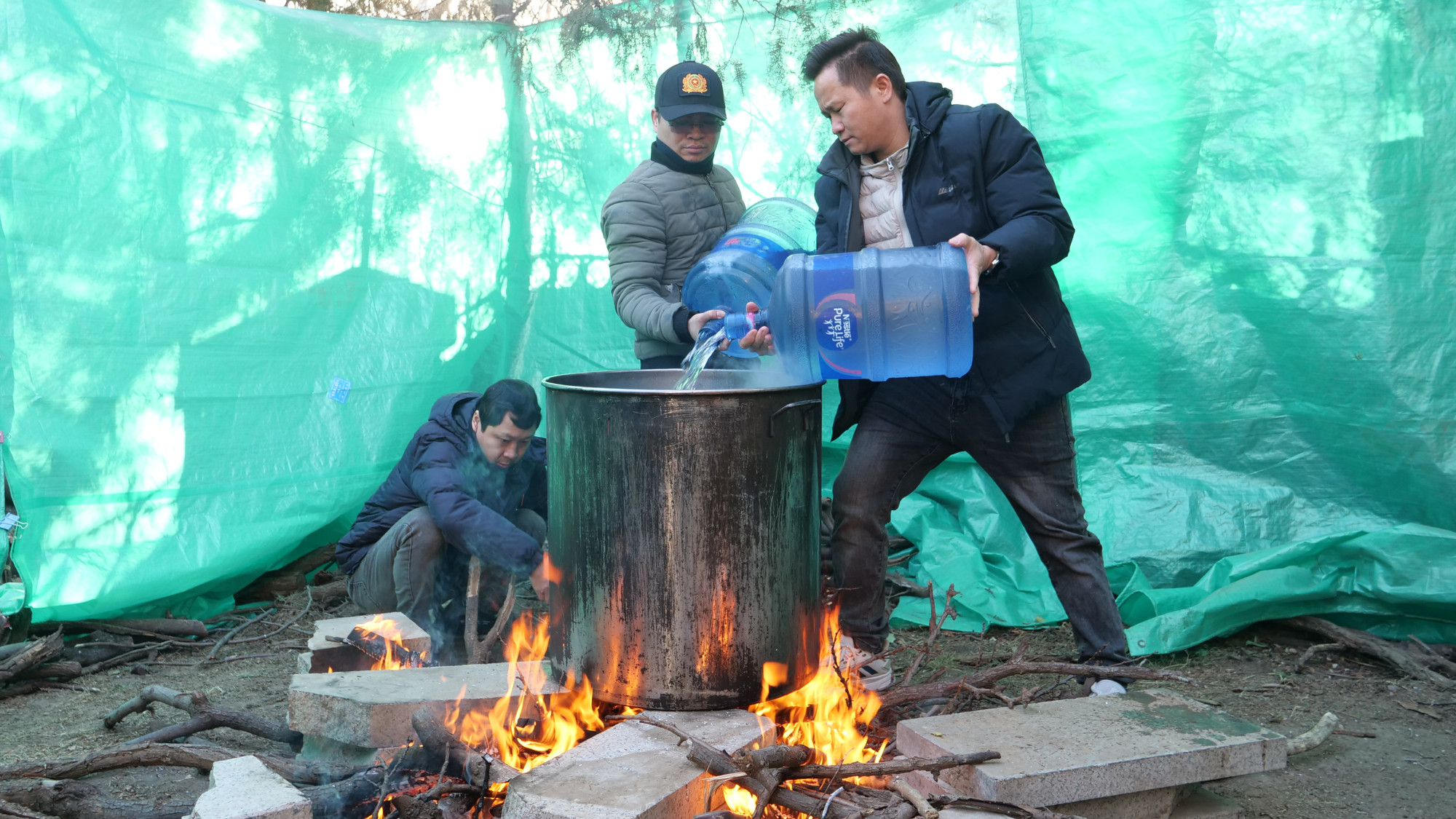 Nhóm bếp củi và đổ nước vào nồi.