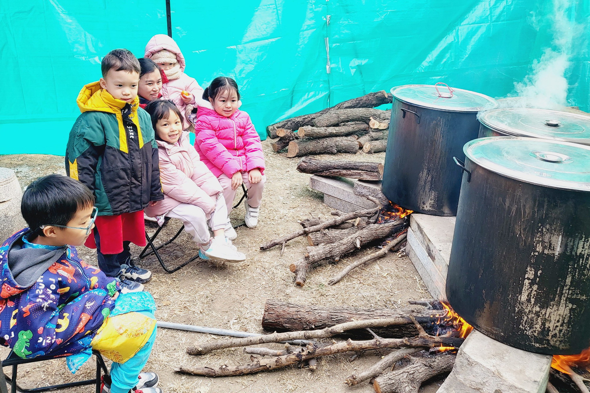 Các cháu thiếu nhi xem luộc bánh chưng bằng bếp củi.