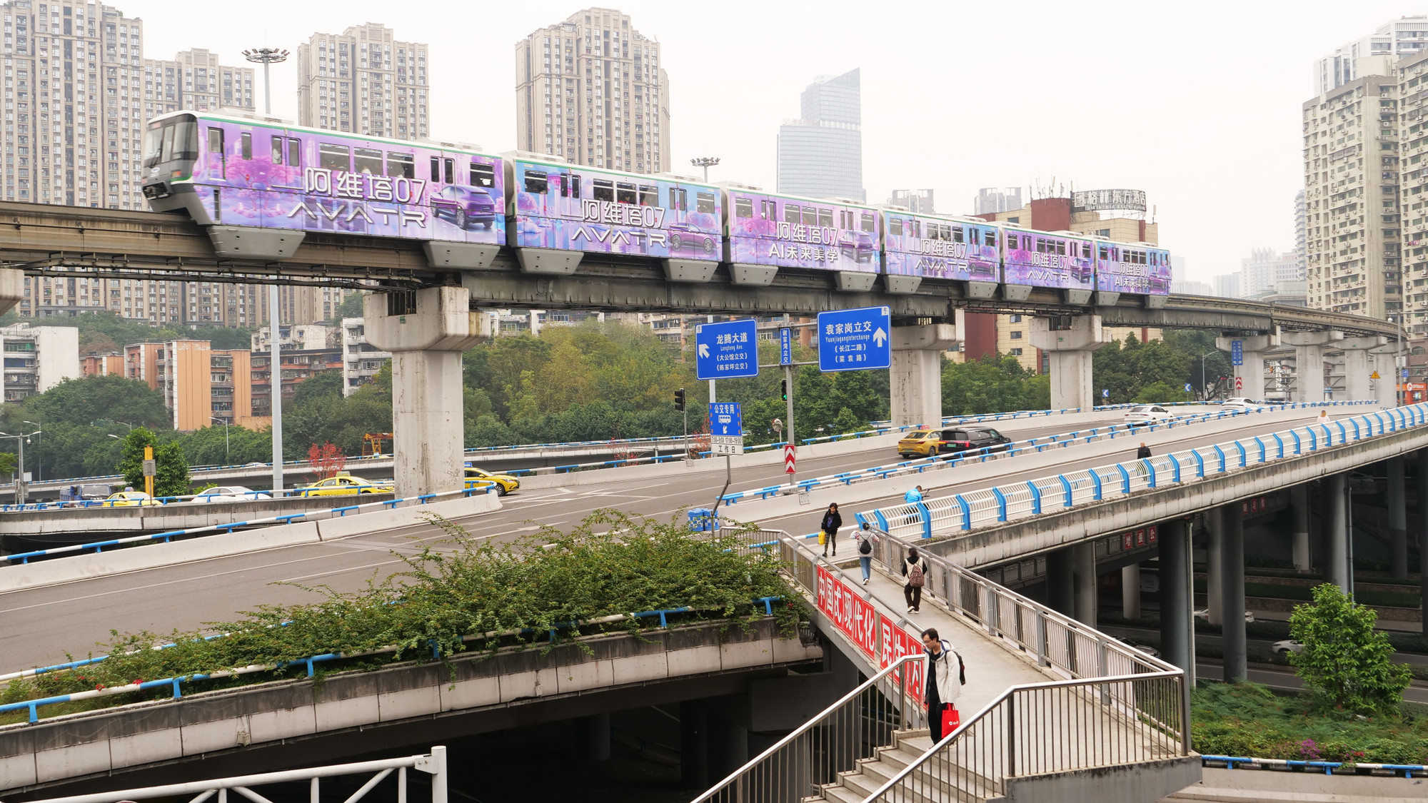 Một góc đường giao thông với tàu điện chạy bên trên, đường cầu vượt và đường đi bộ ở tầng hai.