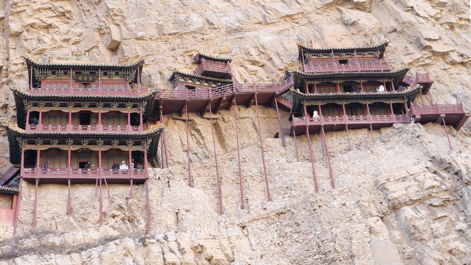 Tuy chỉ cách mặt đất 60m, Huyền Không Tự trông cheo leo, mong manh khi hai tòa lầu gỗ 3 tầng bám vách núi được đỡ bởi những cột gỗ chống xuống vách đá.