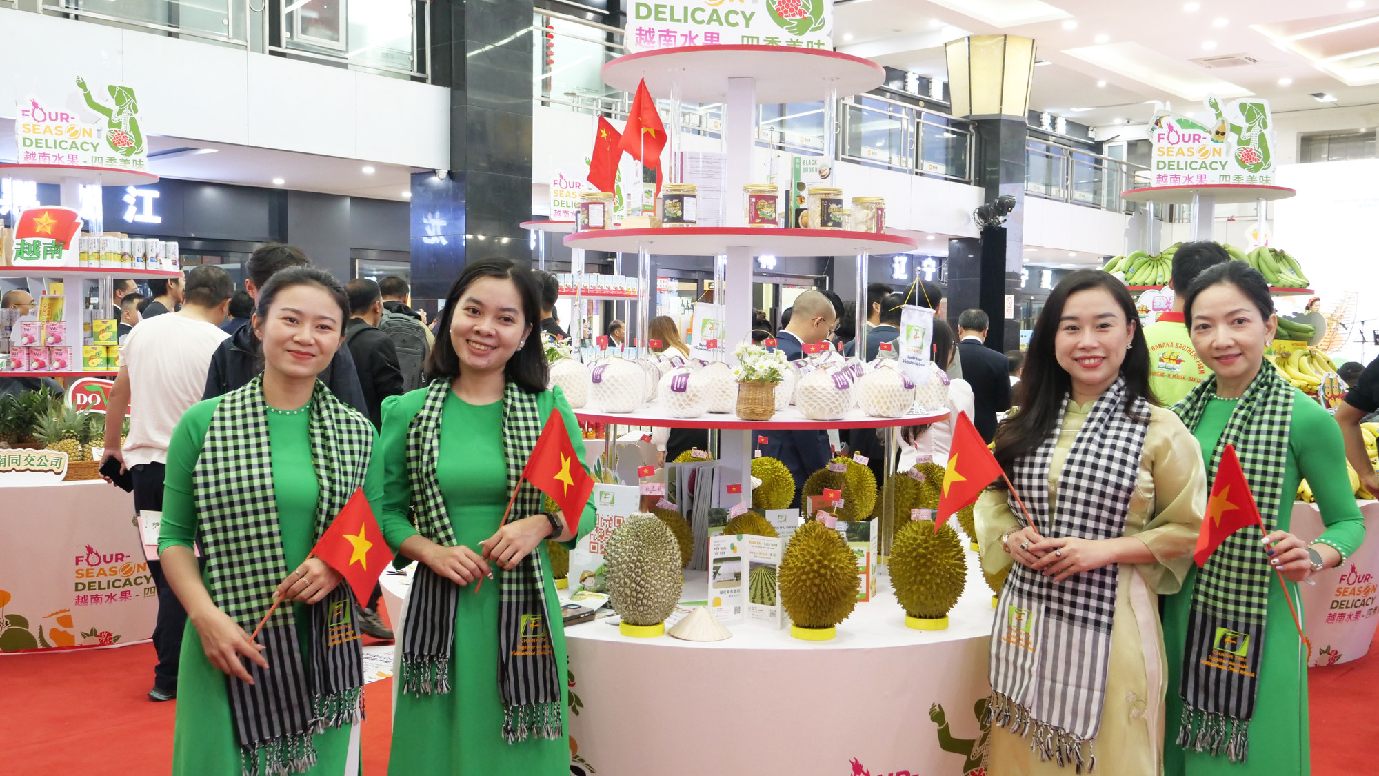 Nhân viên của gian hàng giới thiệu sầu riêng Việt Nam với trang phục áo dài truyền thống và khăn rằn nam bộ.