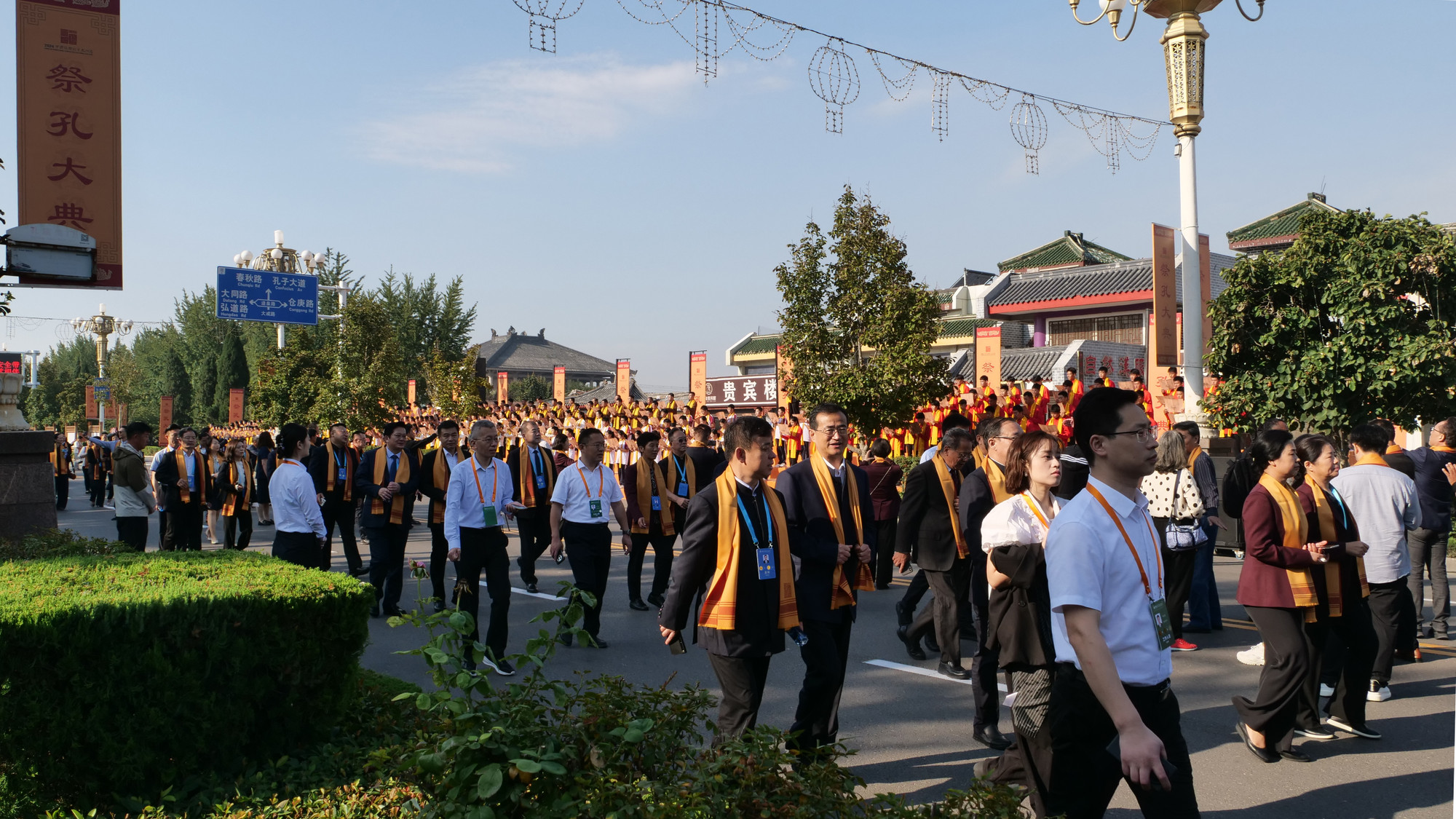 Các đại biểu quàng khăn lễ màu vàng đi bộ vào khu vực trước Khổng miếu.