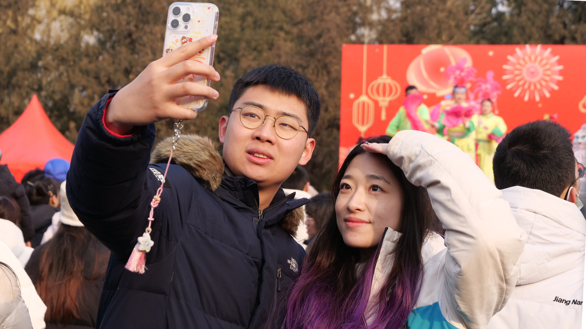 Một đôi bạn trẻ vừa xem biểu diễn vừa tranh thủ chụp ảnh kỷ niệm.