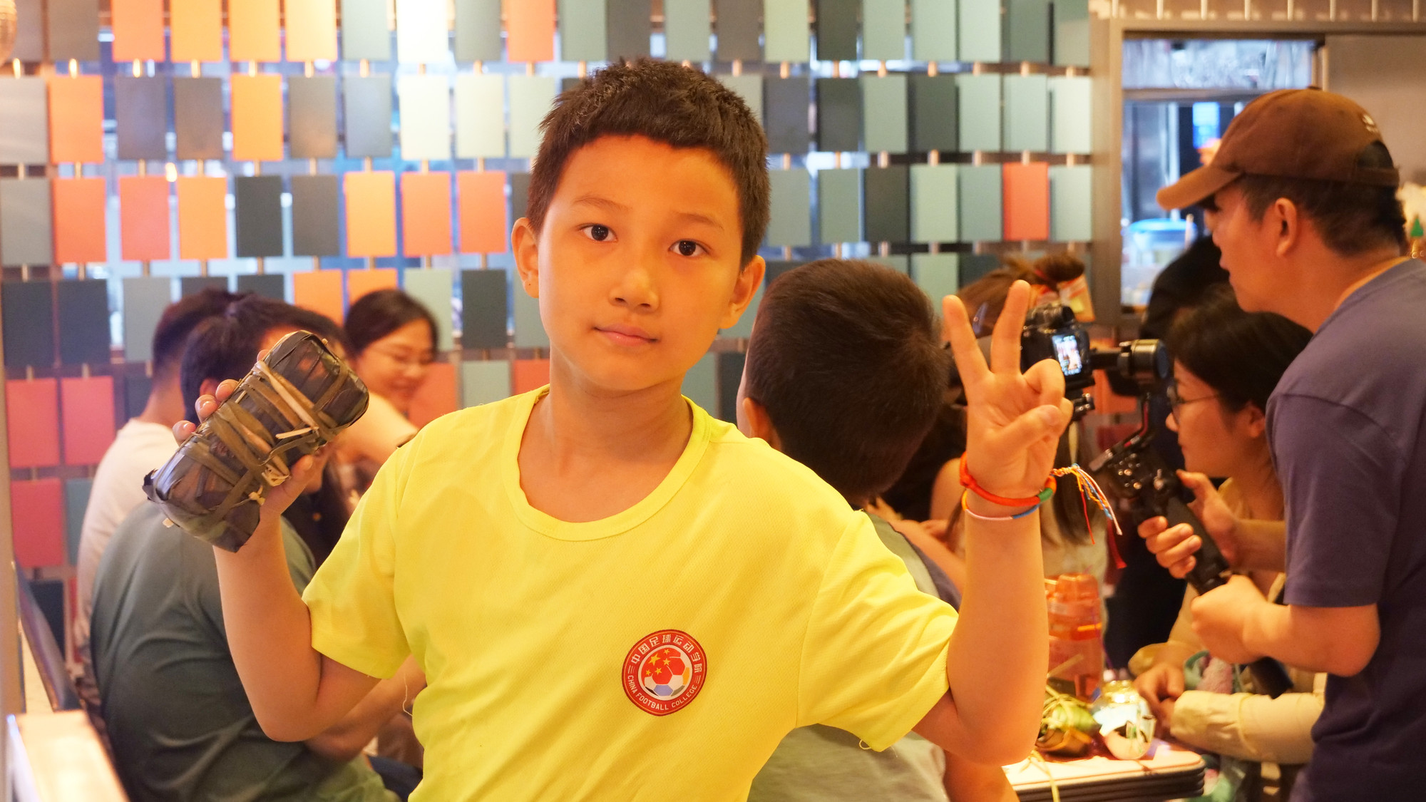 Một thiếu niên thủ đô Bắc Kinh khoe chiếc bánh chưng tự gói.