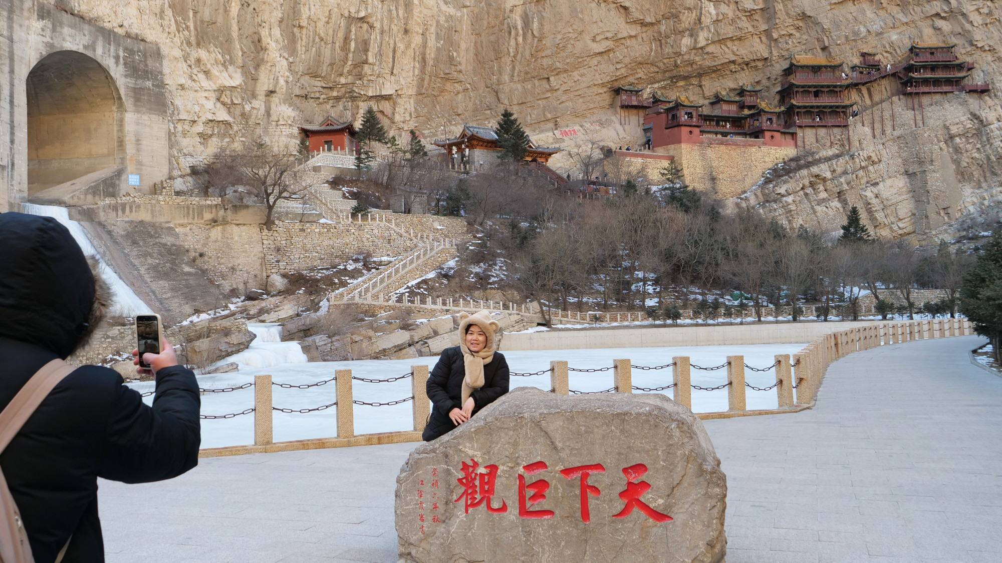Du khách chụp ảnh check-in toàn cảnh Huyền Không Tự với dòng suối dưới chân chùa đóng băng.