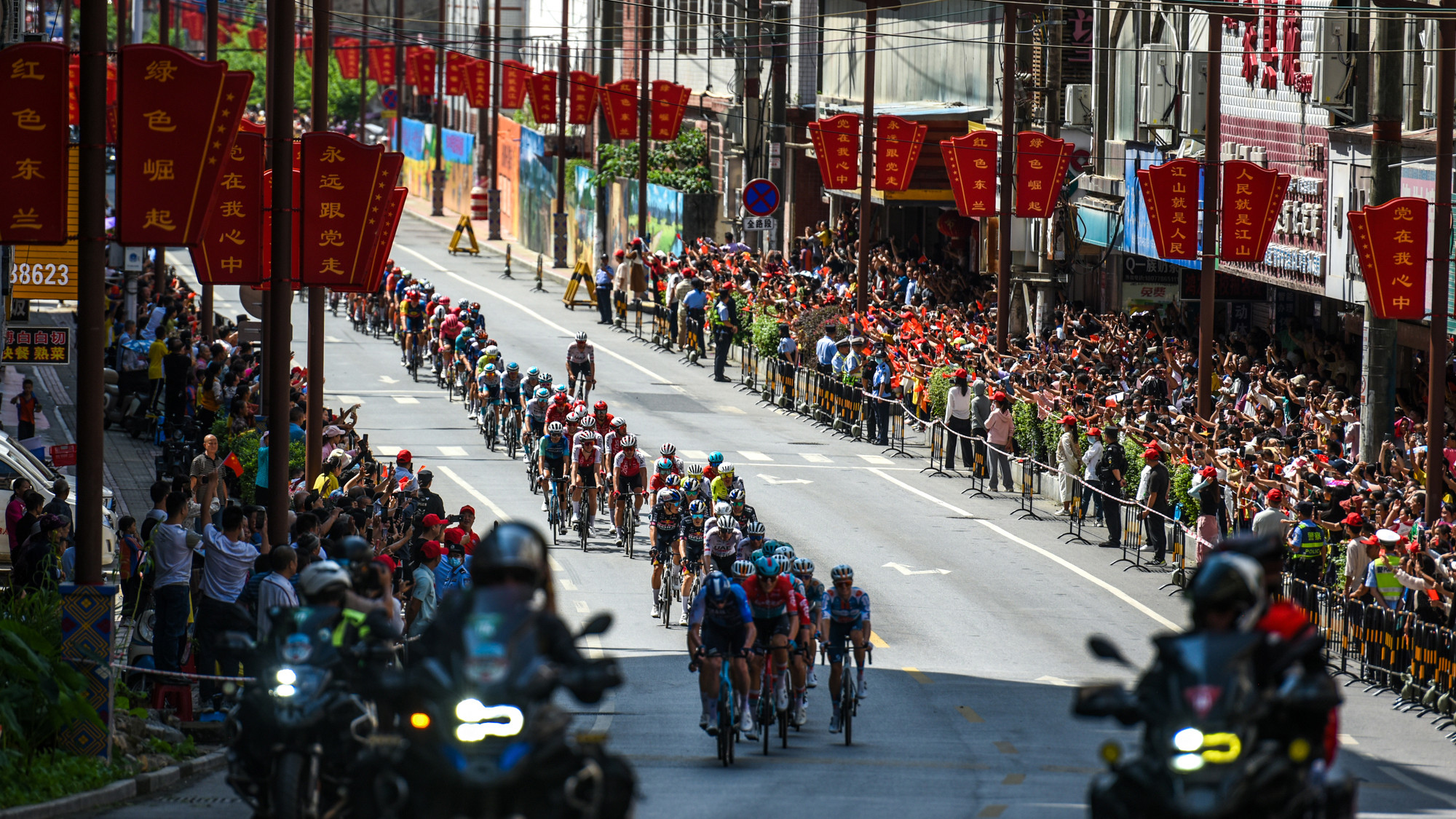 Người dân địa phương đứng kín hai bên đường để chờ đợi, theo dõi và cổ vũ đoàn đua.