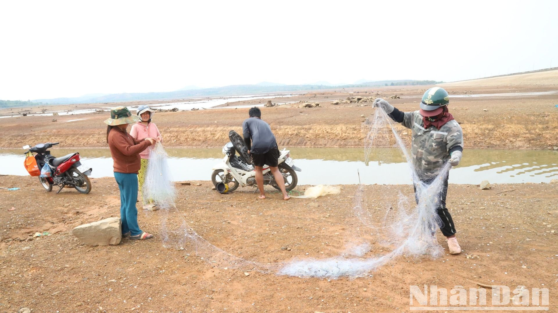 Người dân địa phương tranh thủ lúc hồ cạn nước đến giăng lưới đánh bắt thủy sản.
