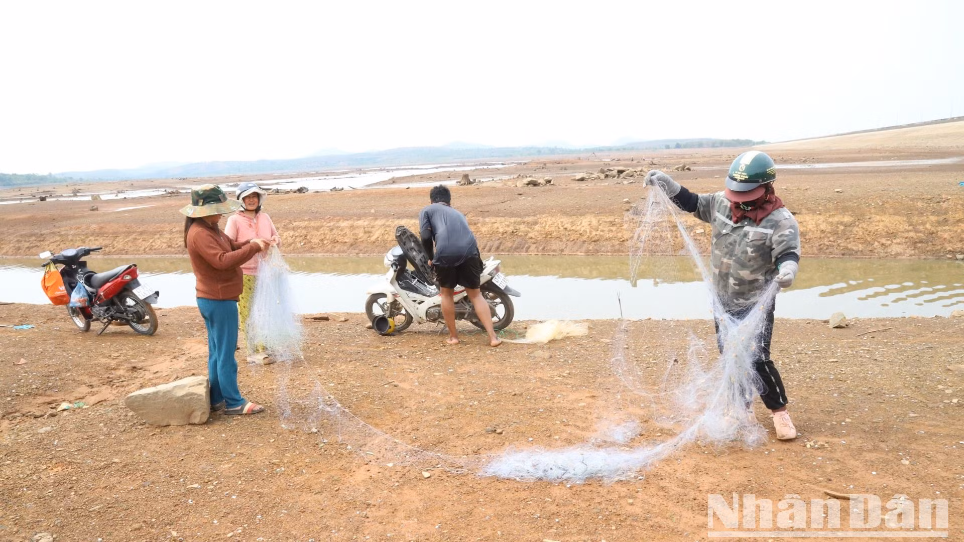 Người dân địa phương tranh thủ lúc hồ cạn nước đến giăng lưới đánh bắt thủy sản.