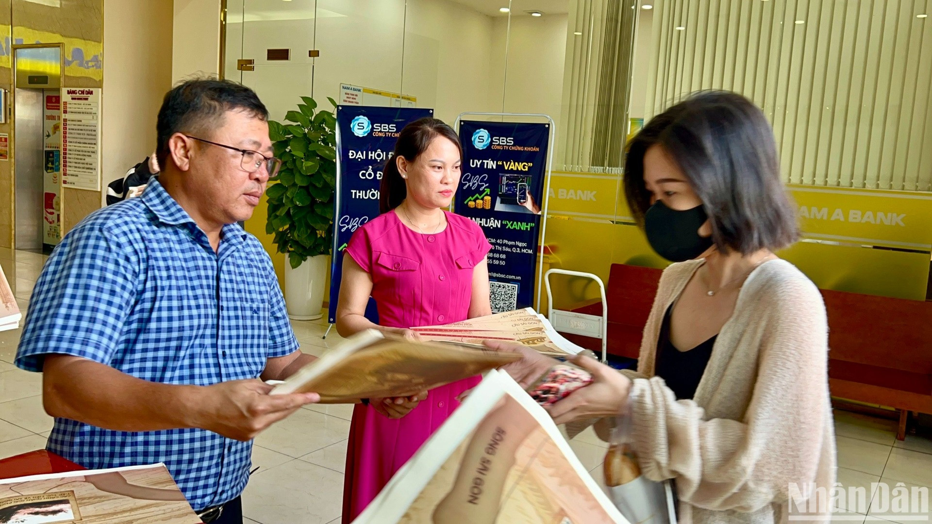 Lãnh đạo, phóng viên Cơ quan đại diện Báo Nhân Dân tại khu vực miền nam trao phụ san đặc biệt cho bạn đọc