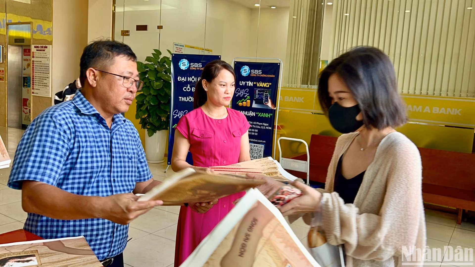 Lãnh đạo, phóng viên Cơ quan đại diện Báo Nhân Dân tại khu vực miền nam trao phụ san đặc biệt cho bạn đọc