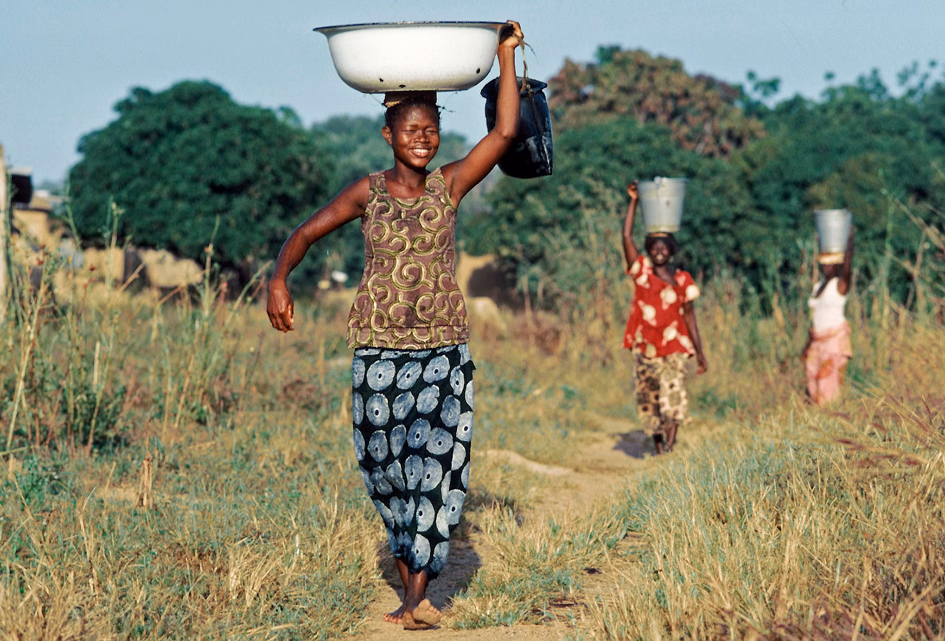 Nụ cười của những người phụ nữ làng Po trở về nhà với những xô, chậu chứa đầy nước, ngày 1/1/1976.