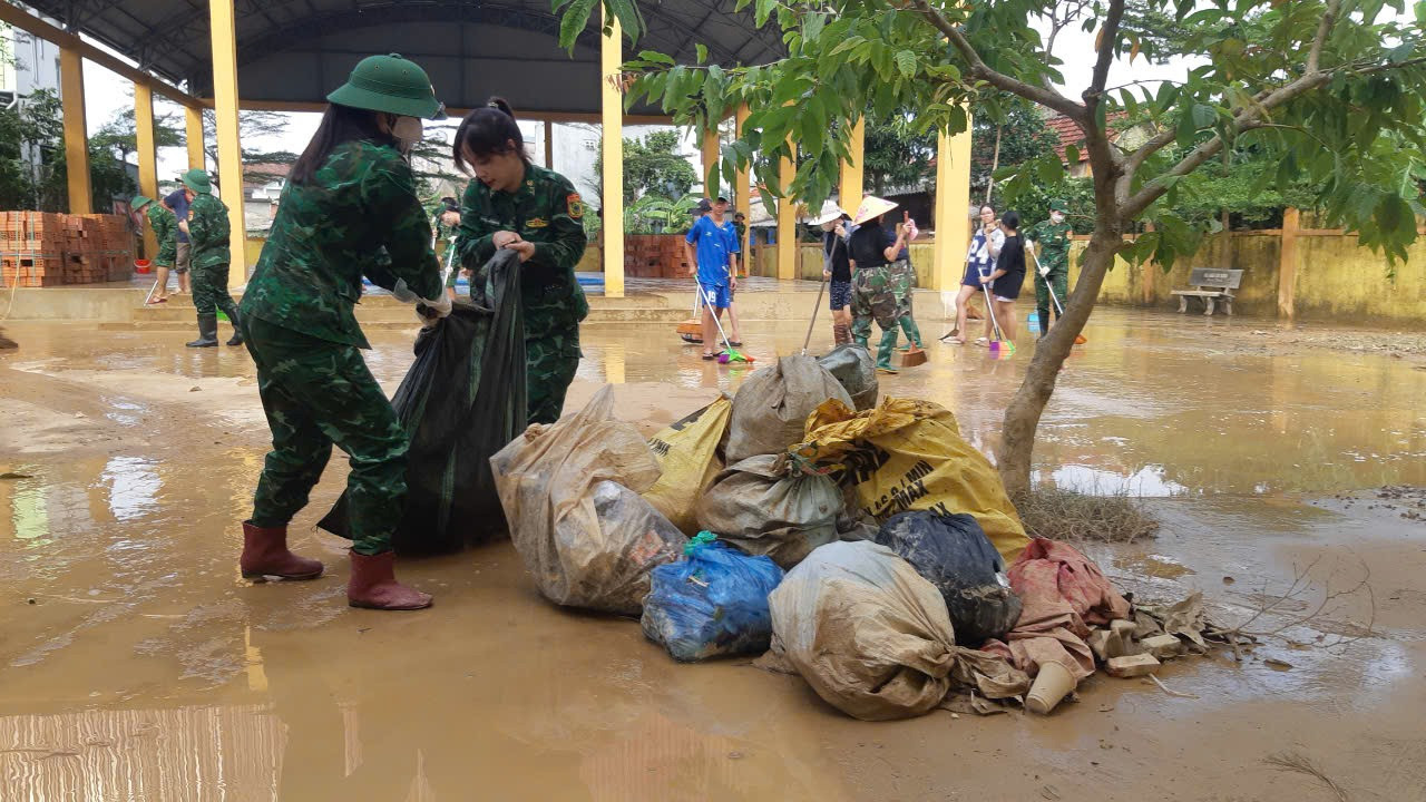 Sau lũ, cơ man nào là rác nhưng phải dọn sạch để bảo đảm môi trường sạch sẽ cho trường học.