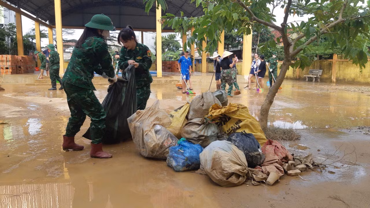 Sau lũ, cơ man nào là rác nhưng phải dọn sạch để bảo đảm môi trường sạch sẽ cho trường học.