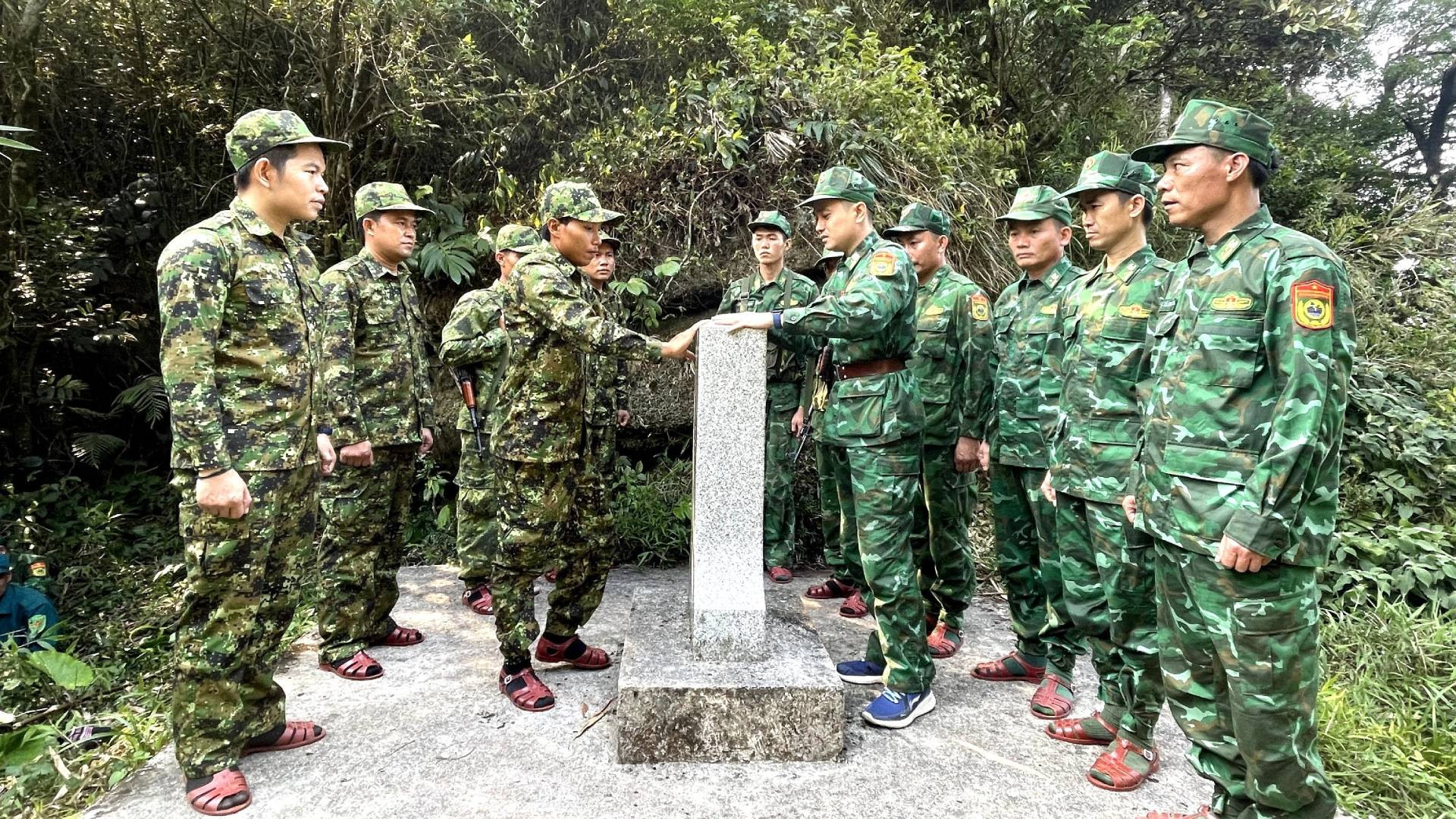 Sau một thời gian dài hành quân trong điều kiện thời tiết và khí hậu khắc nghiệt, lực lượng bảo vệ biên giới 2 tỉnh của Việt Nam và Lào đến được cột mốc số 522 nằm ở vị trí cao nhất trên đỉnh núi Giăng Màn, cao gần 2.000m so mực nước biển. Trong ảnh: Lực lượng 2 bên làm thủ tục đầu tiên chạm vào cột mốc quốc giới.