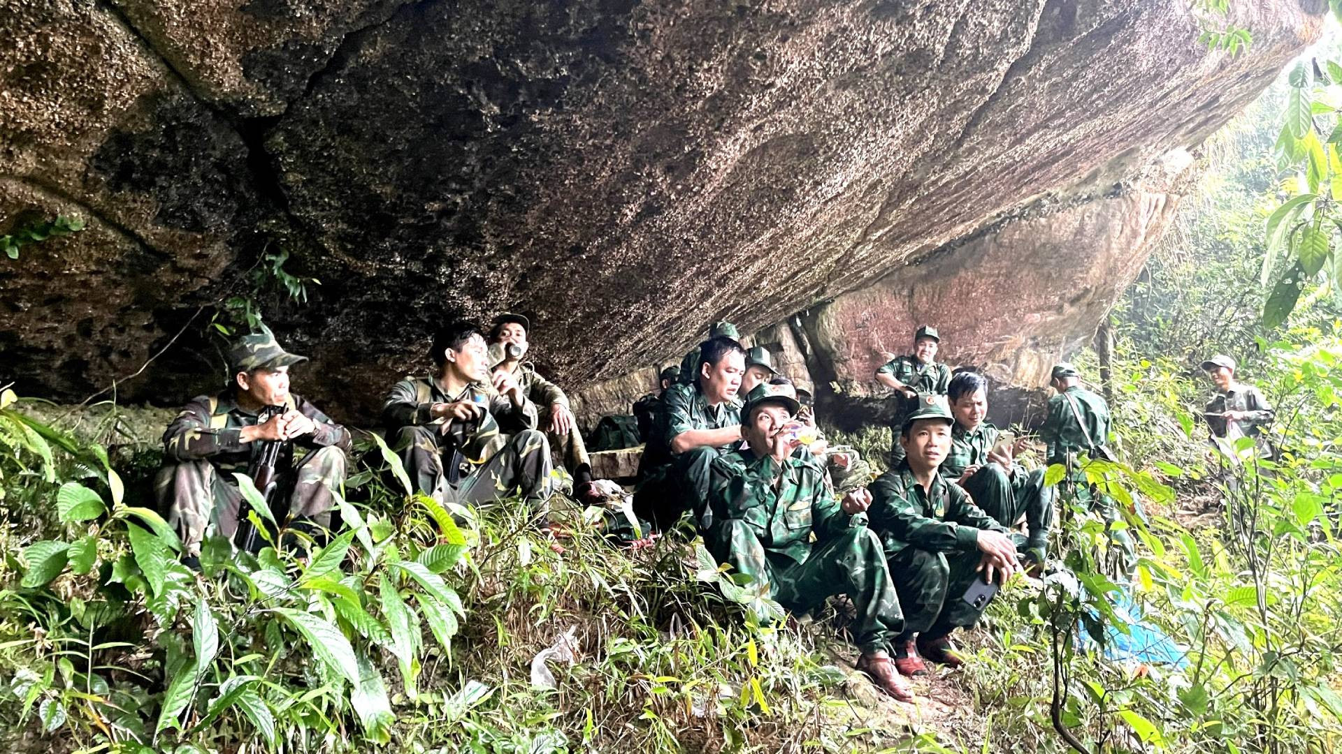 Sau nửa ngày hành quân, các cán bộ, chiến sĩ bảo vệ biên giới 2 tỉnh Quảng Bình và Khammouane dừng chân nghỉ ngơi dưới một tảng đá khổng lồ vươn ra che cả một không gian rộng lớn trên dãy núi Giăng Màn.