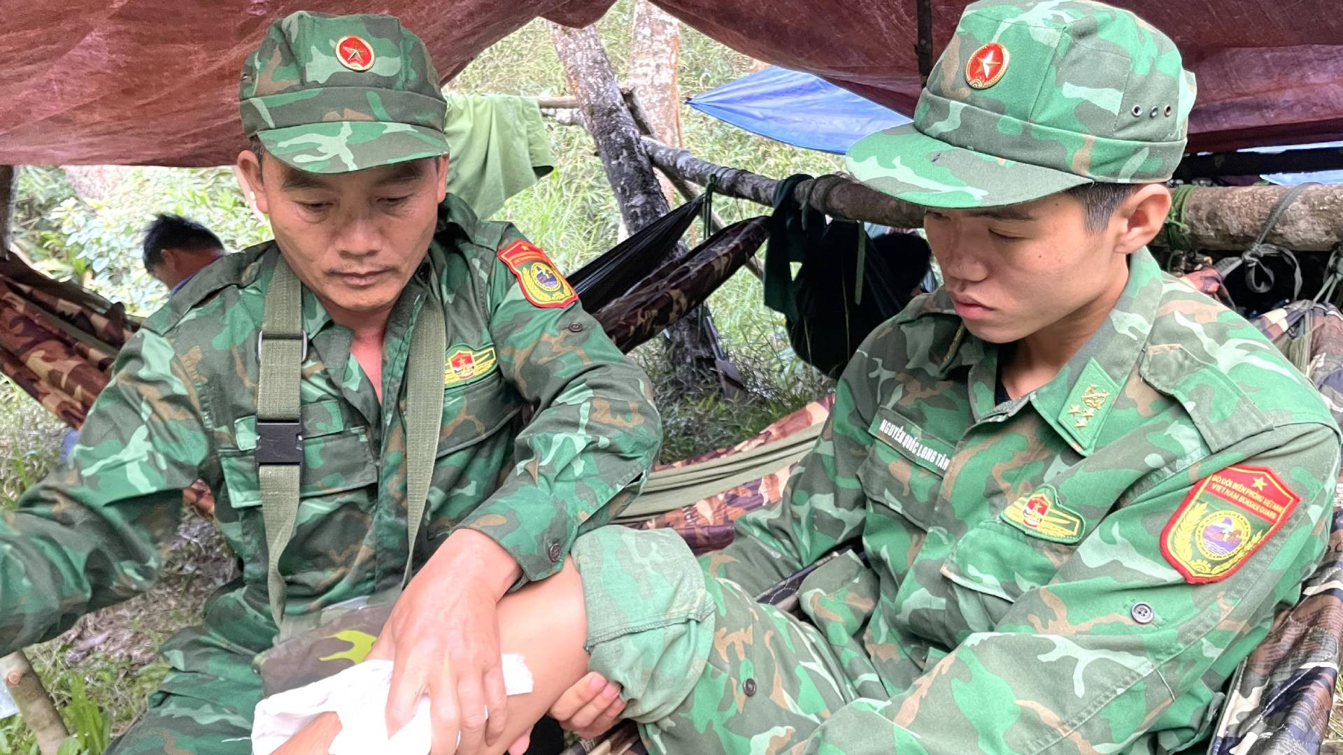 Tranh thủ lúc nghỉ ngơi, Thiếu tá Trần Xuân Hanh, cán bộ Quân y Đồn Biên phòng cửa khẩu quốc tế Cha Lo xoa bóp chân cho một đồng chí bị sưng tấy trong chuyến hành quân dài ngày nhiều vất vả.