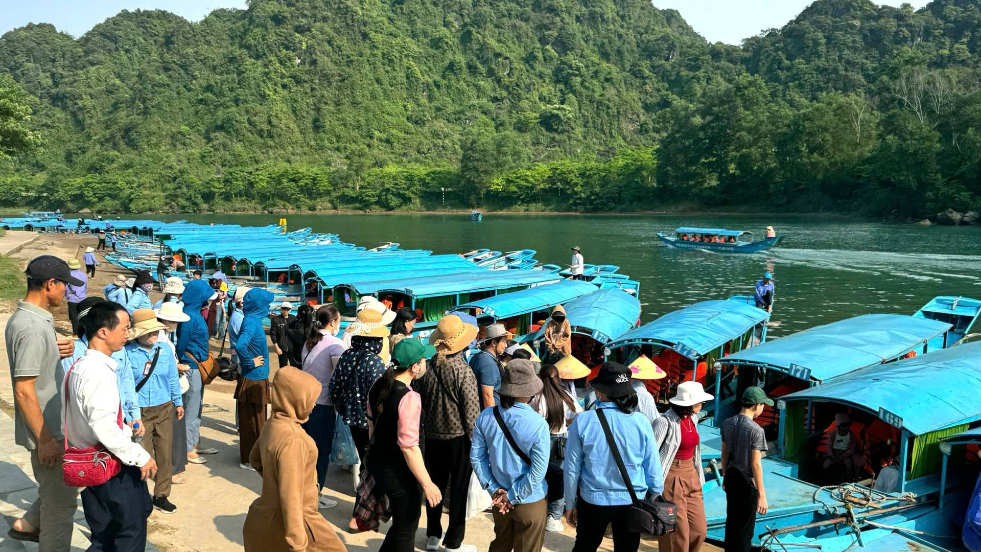 Từ sáng sớm, bến thuyền du lịch Phong Nha đã rất đông người xếp hàng mua vé rồi xuống thuyền để ngược dòng sông Son thăm hang động.
