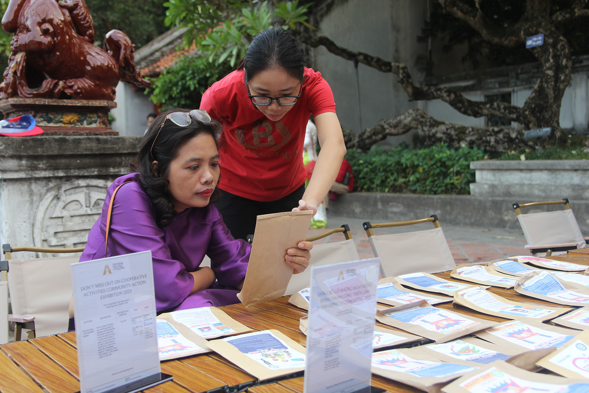 Nhân viên của Vụn Art hướng dẫn khách tham quan trải nghiệm ghép tranh từ vải lụa. Khách tham quan có thể mua về hoặc ghép trực tiếp tại chỗ.