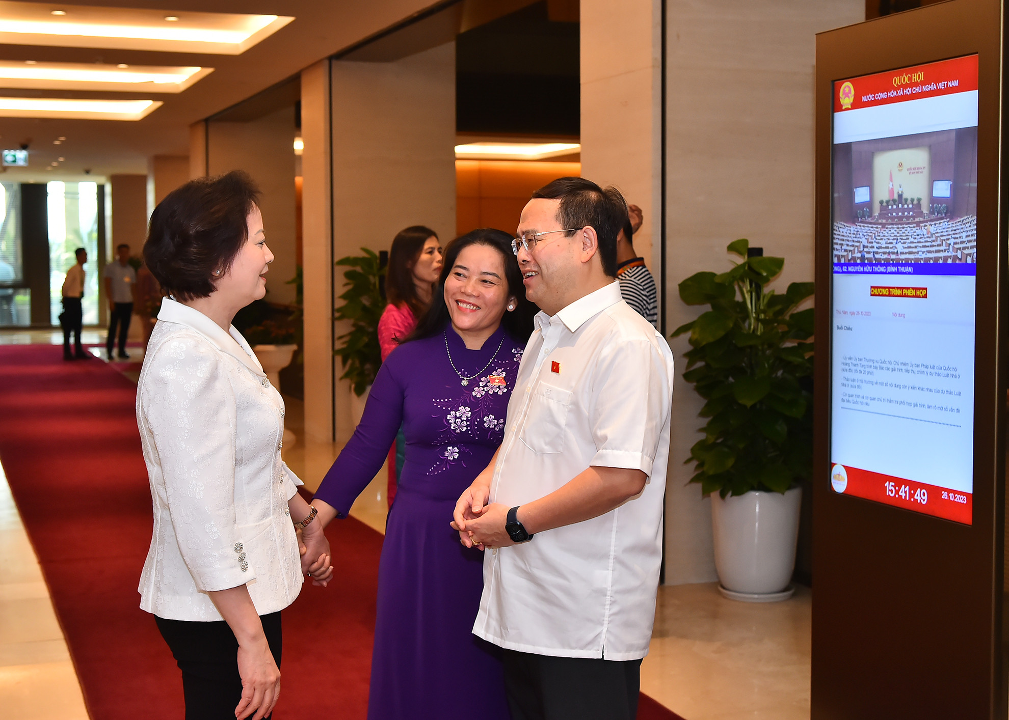 Các đại biểu Quốc hội trao đổi bên lề phiên họp ngày 26/10.