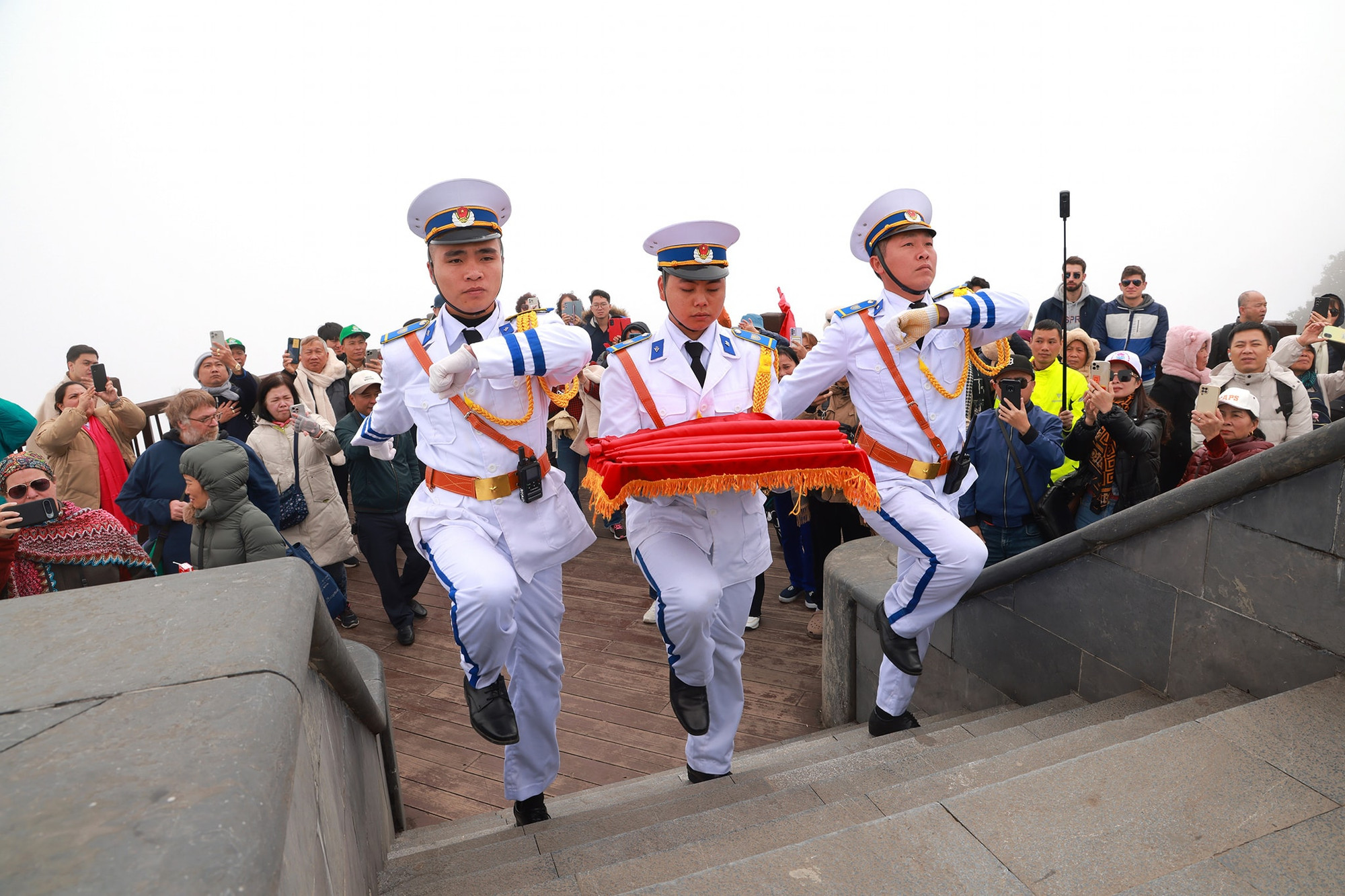 Đội tiêu binh xuất hiện trên nền nhạc lễ, du khách dừng mọi hoạt động để dõi theo.