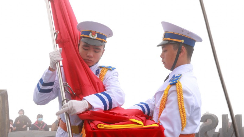 Cờ Tổ quốc được ôm giữ trước khi kéo lên cao.