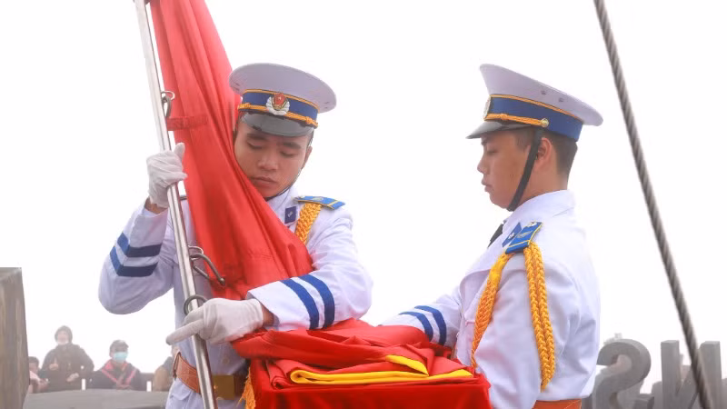 Cờ Tổ quốc được ôm giữ trước khi kéo lên cao.