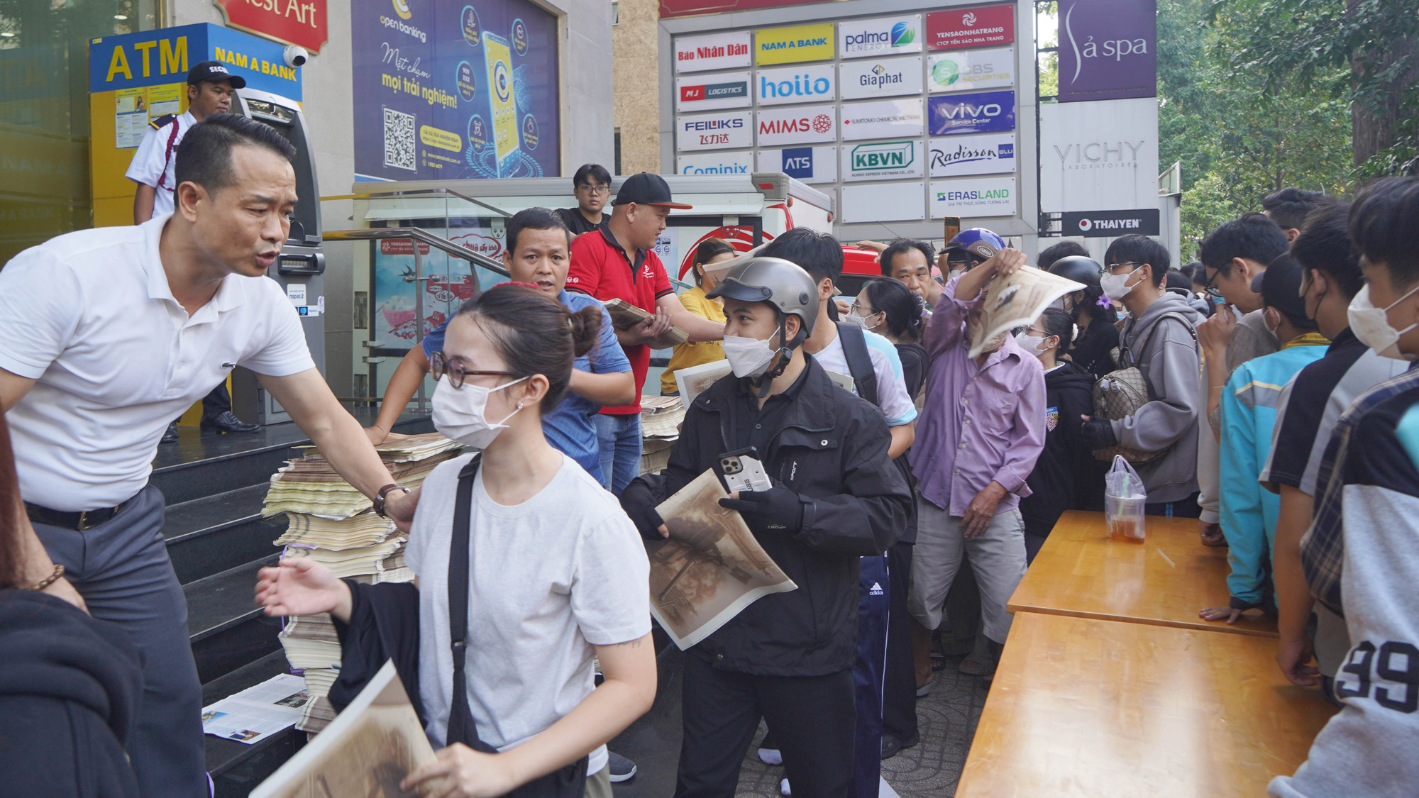 Lãnh đạo, phóng viên Cơ quan đại diện Báo Nhân Dân tại khu vực miền nam trao phụ san đặc biệt cho bạn đọc.