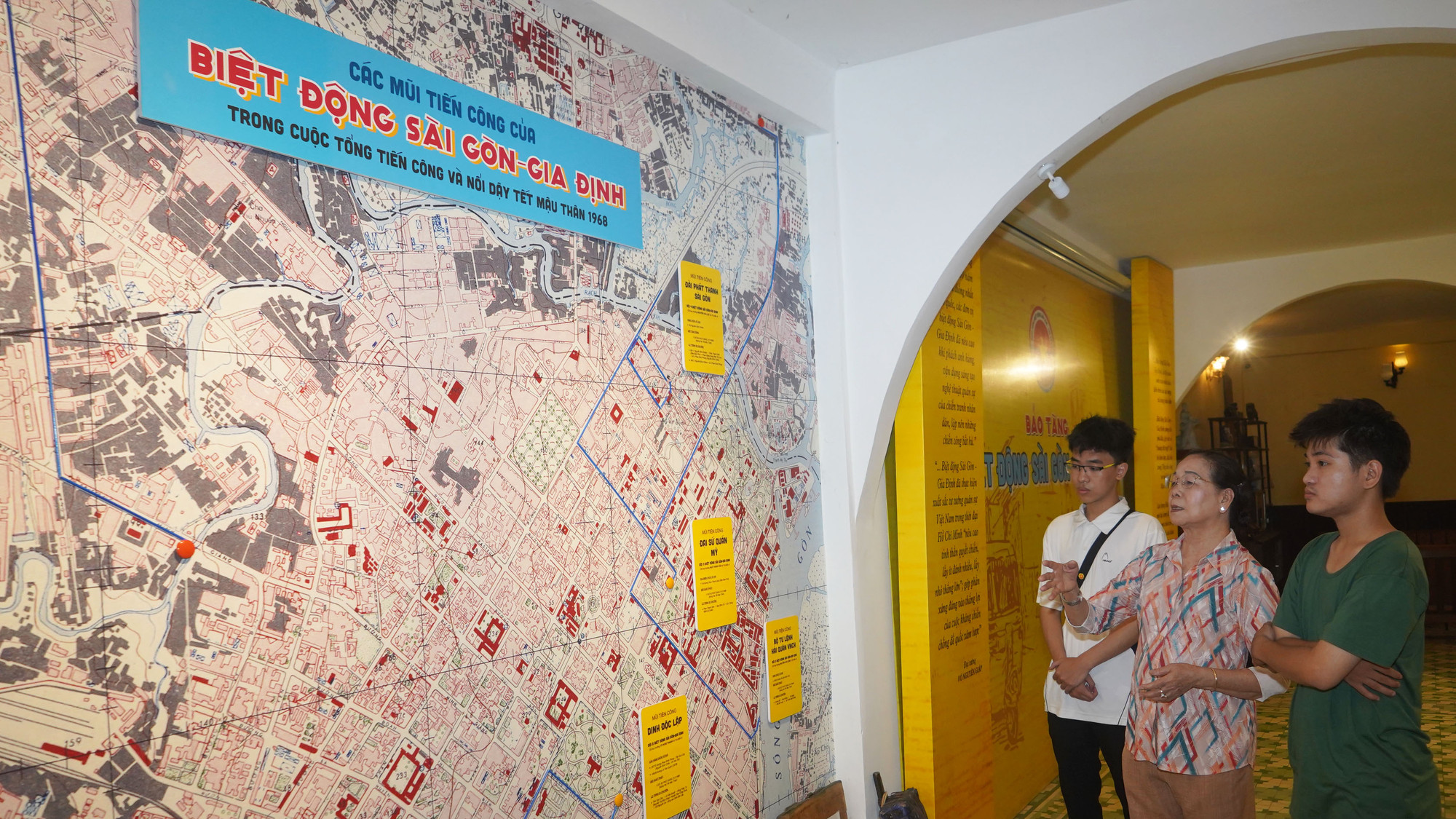 Người đứng giữa: Bà Vũ Minh Nghĩa (Chín Nghĩa), nhân chứng lịch sử giới thiệu cho các bạn trẻ đến tham quan Bảo tàng Biệt động Sài Gòn-Gia Định.