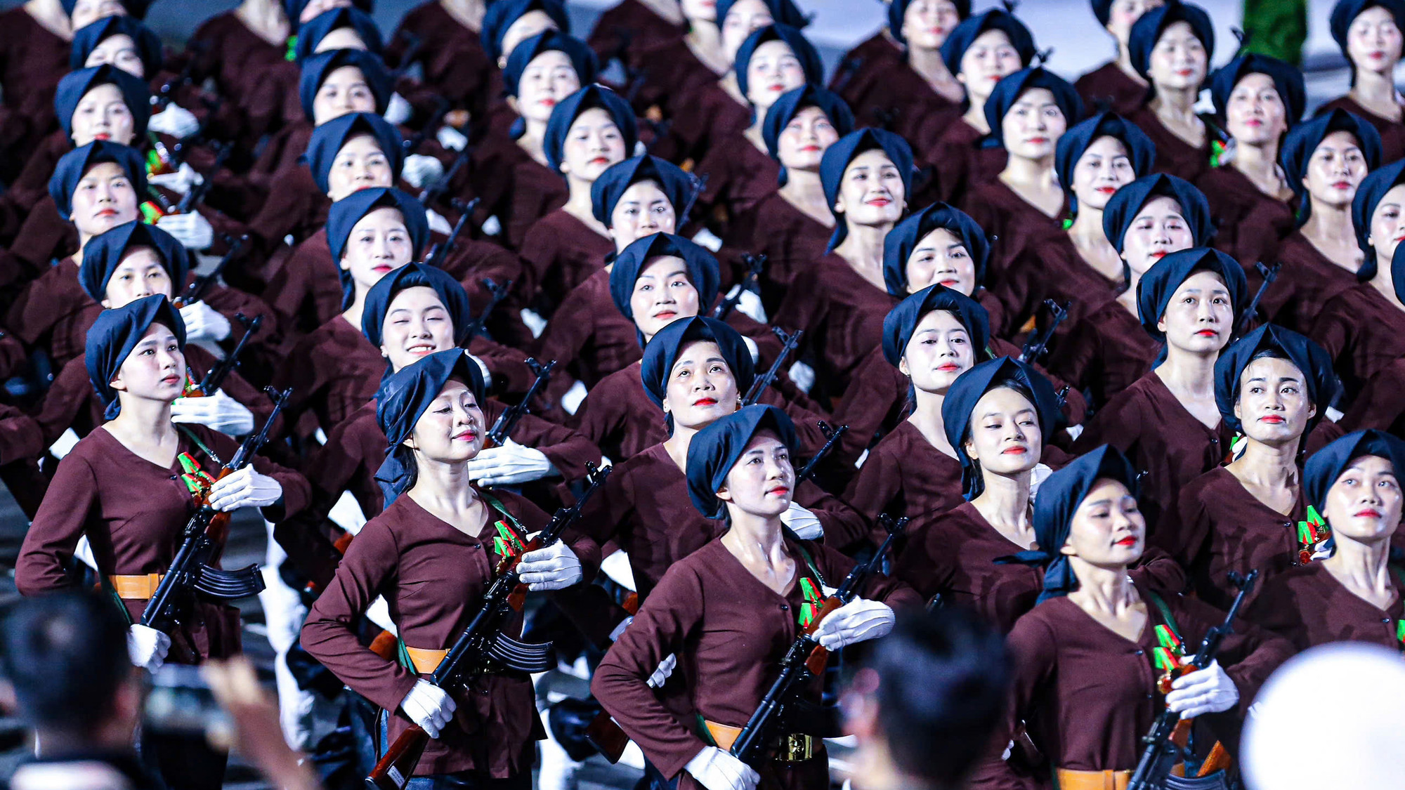 Khối nữ dân quân tái hiện hình ảnh người phụ nữ miền bắc thời kháng chiến, với trang phục khăn mỏ quạ, áo nâu sẫm. Khối nữ dân quân tái hiện hình ảnh người phụ nữ miền bắc thời kháng chiến, với trang phục khăn mỏ quạ, áo nâu sẫm.