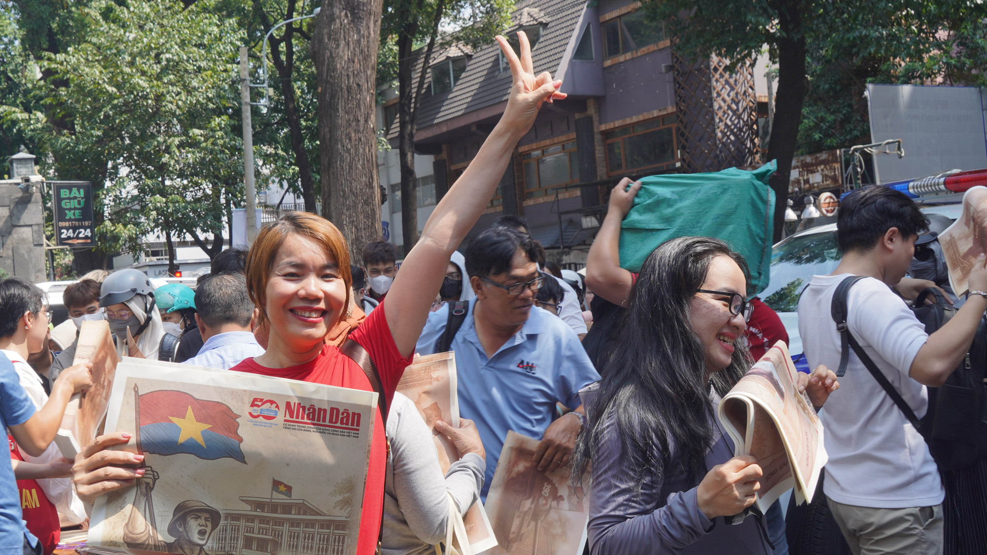 Bạn đọc vui mừng khi nhận được tờ phụ san đặc biệt tuyên truyền Kỷ niệm 50 năm Ngày Giải phóng miền nam, thống nhất đất nước của Báo Nhân Dân.