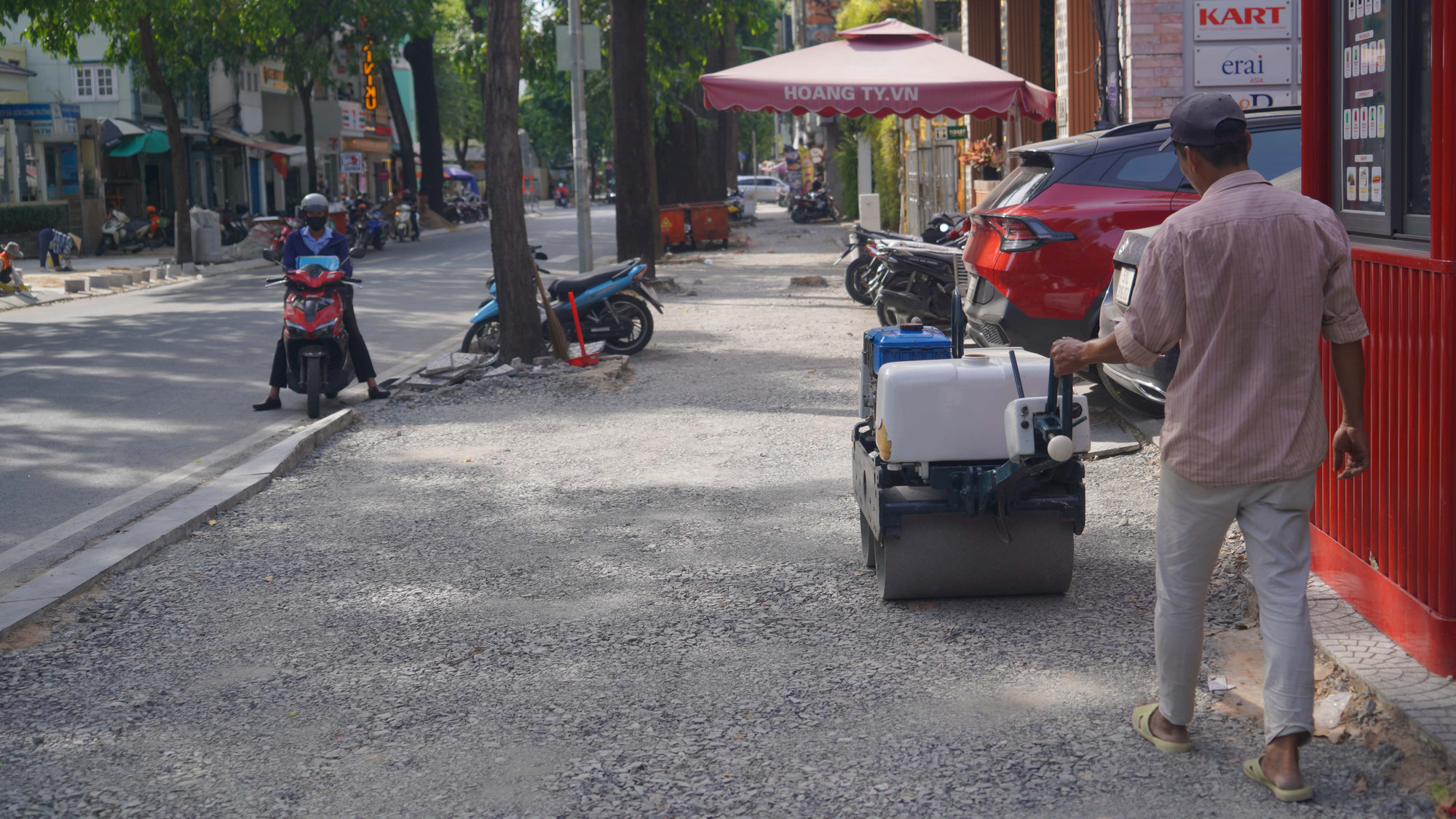 Công nhân lu nền đất vỉa hè trên đường Mạc Đĩnh Chi, Quận 1.