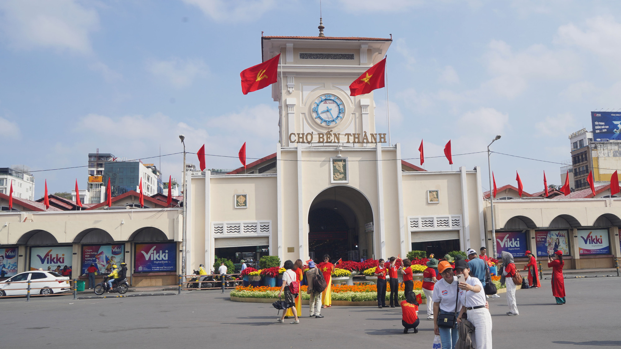 Người dân,du khách nước ngoài dạo bước dưới ánh cờ rực rỡ trước cổng chợ Bến Thành,ai nấy đều không giấu được niềm tự hào dân tộc trong những ngày tháng tư lịch sử.