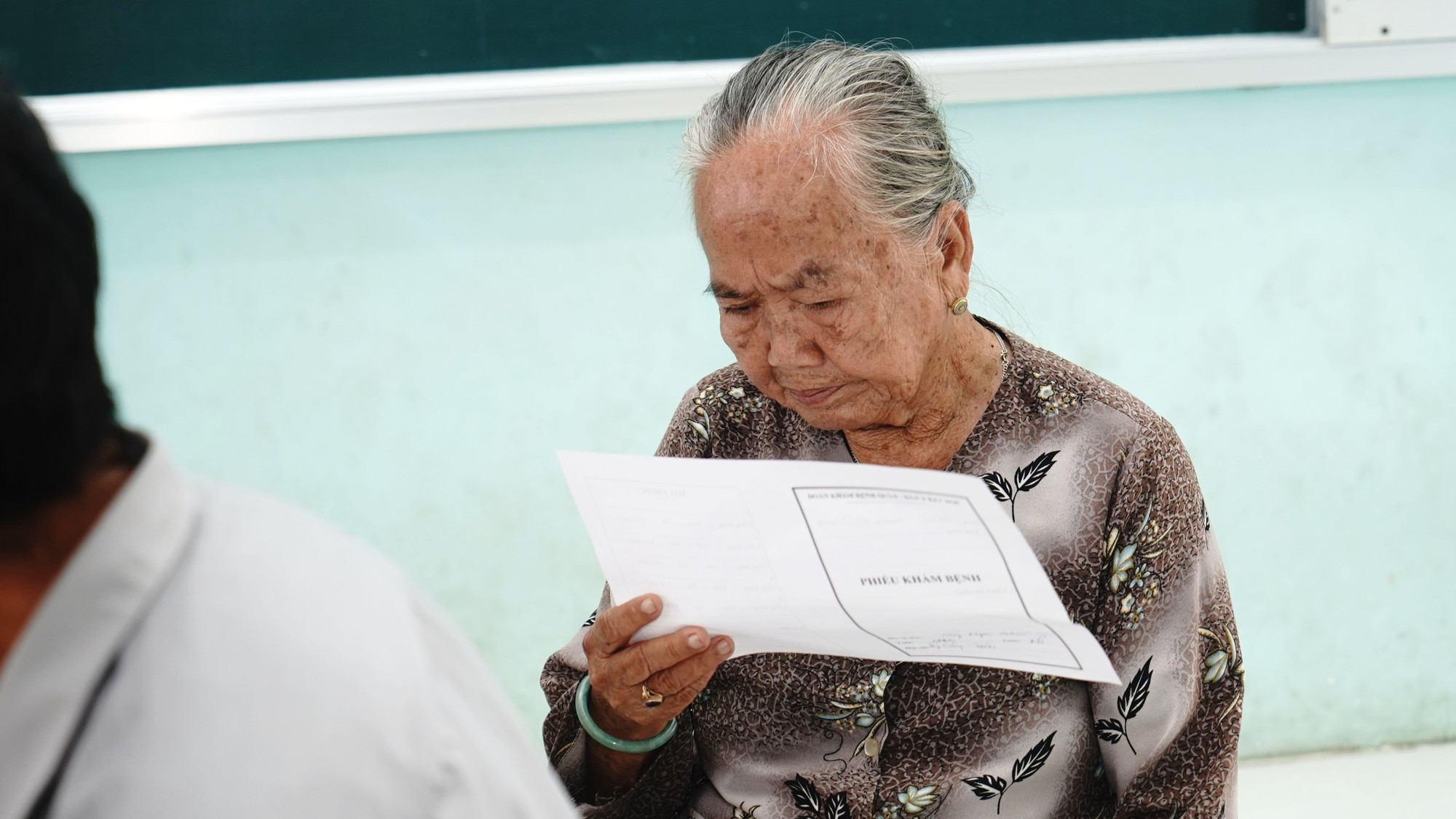 Các bà mẹ gia đình chính sách tranh thủ chờ được khám bệnh.