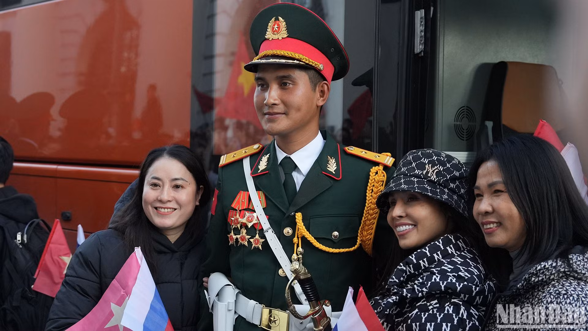 Bà con người Việt Nam tại Nga vui vẻ chụp ảnh lưu niệm với quân nhân Việt Nam tham gia hợp luyện chuẩn bị cho Lễ duyệt binh tại Quảng trường Đỏ.