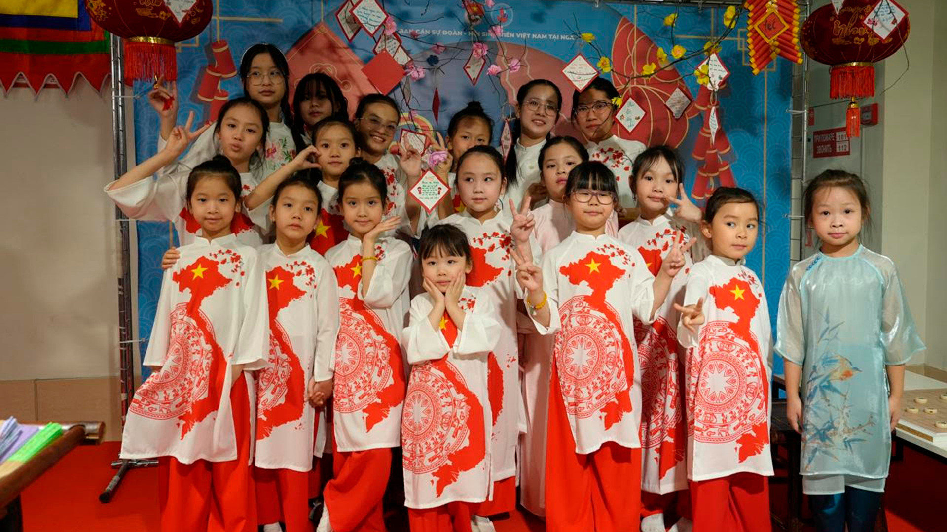 Các em nhỏ trong tà áo dài in hình Tổ quốc trải nghiệm Ngày Tết cổ truyền.