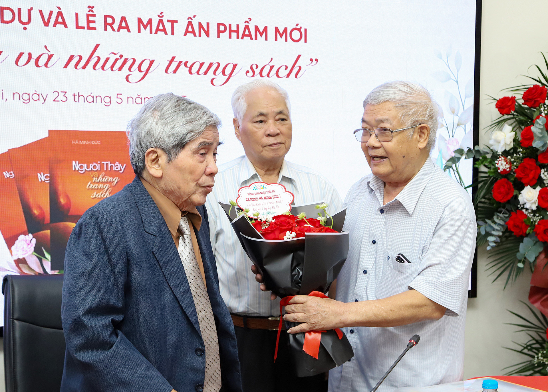 Giáo sư Hà Minh Đức nhận hoa chúc mừng từ học trò cũ. (Ảnh: HỮU TOÀN)