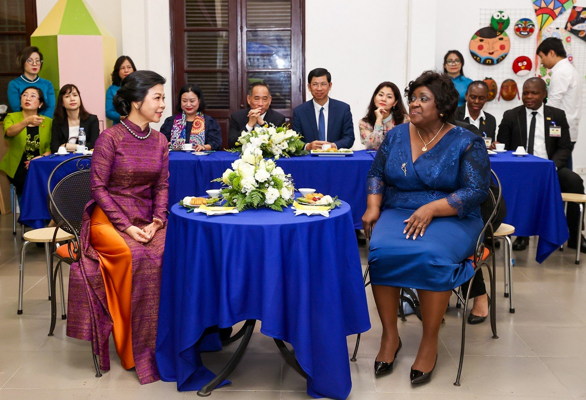 Phu nhân Tổng Bí thư, Chủ tịch nước Tô Lâm, bà Ngô Phương Ly và Phu nhân Tổng thống Mozambique Filipe Jacinto Nyusi, bà Isaura Ferrao Nyusi thưởng thức trà và bánh Trung thu trong khi xem giới thiệu quá trình sáng tác tranh sơn mài.