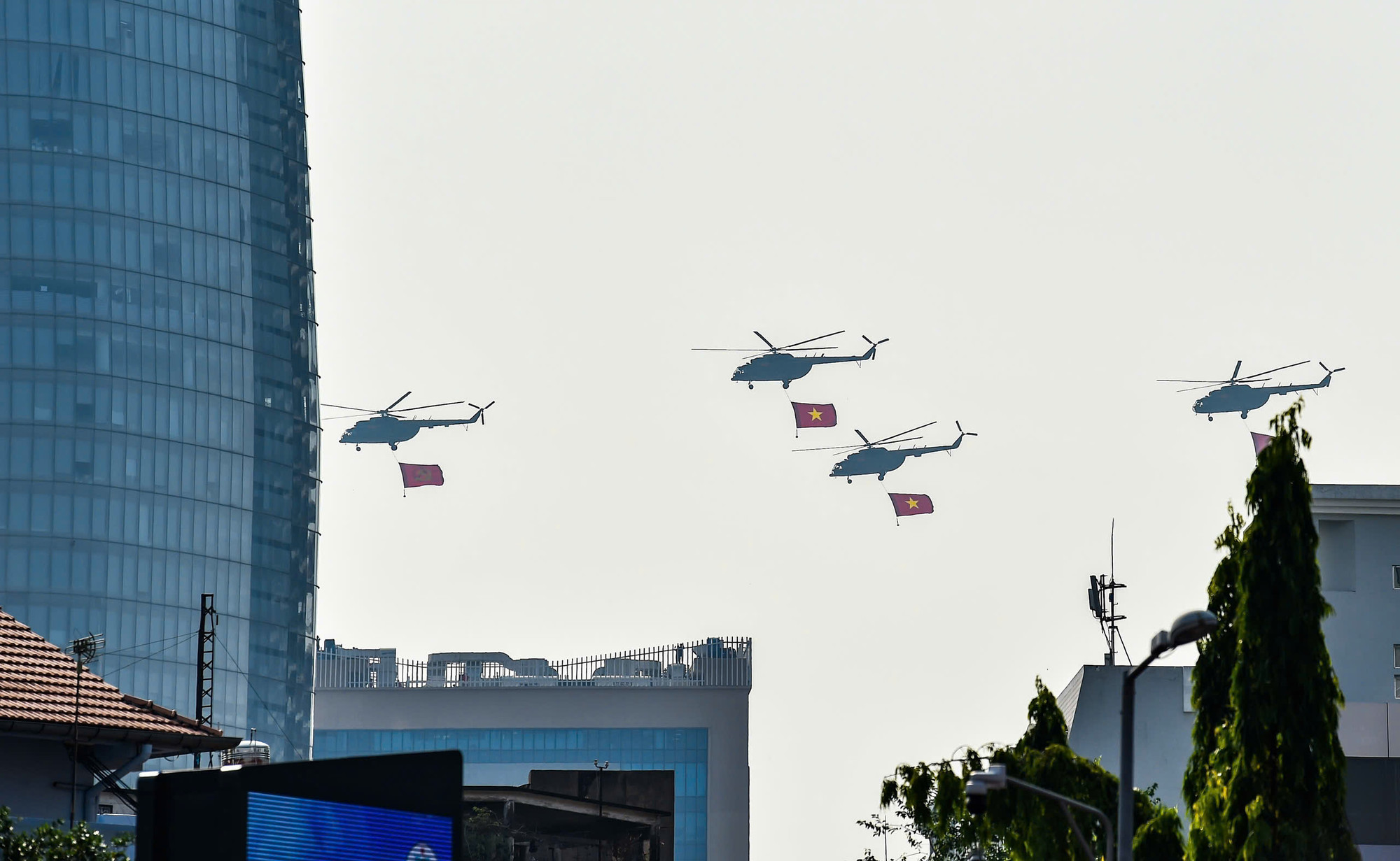 Máy bay trực thăng mang theo cờ Đảng, cờ Tổ quốc trên bầu trời Thành phố Hồ Chí Minh.