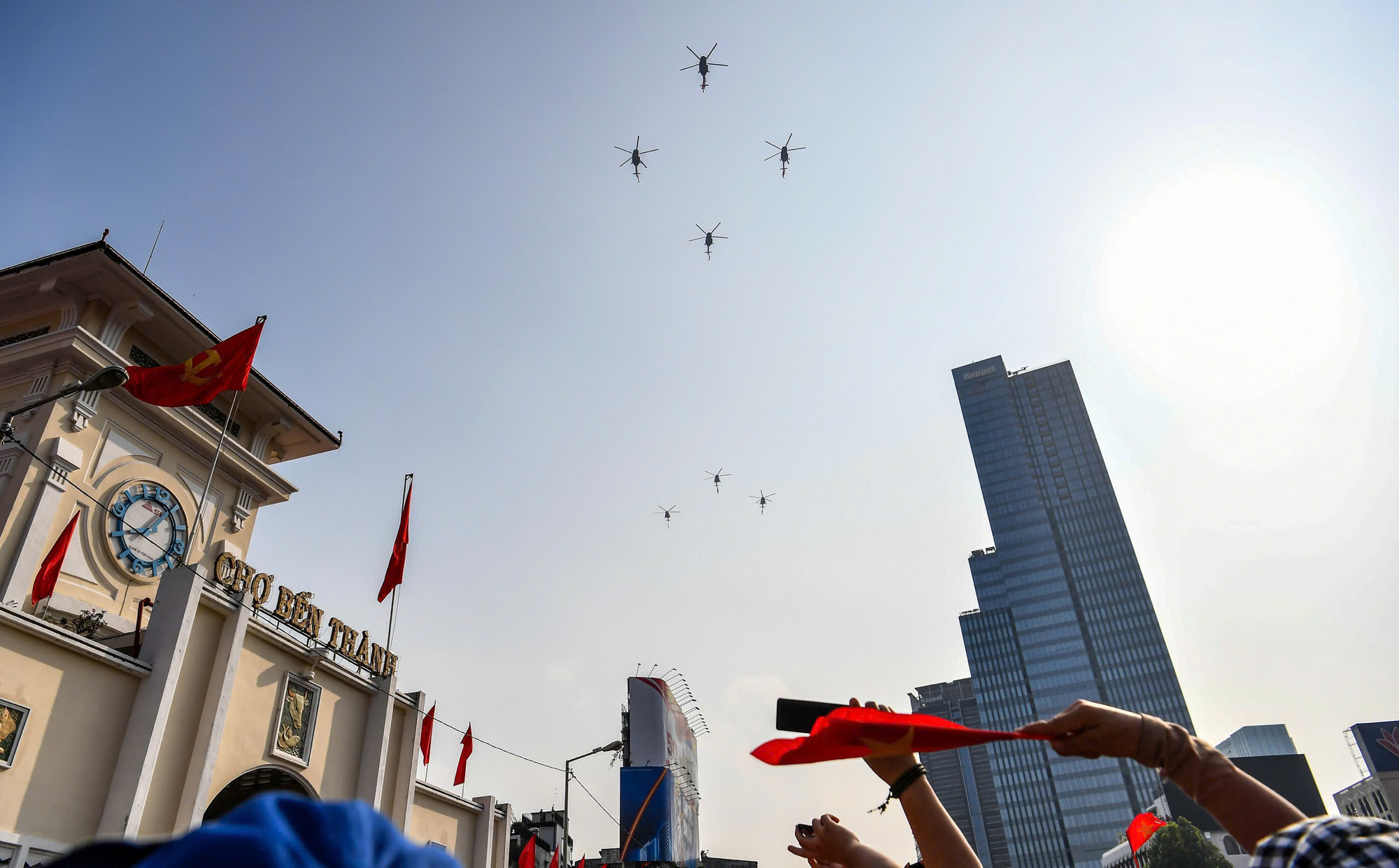 Người dân ngắm nhìn máy bay trực thăng bay qua khu vực chợ Bến Thành.