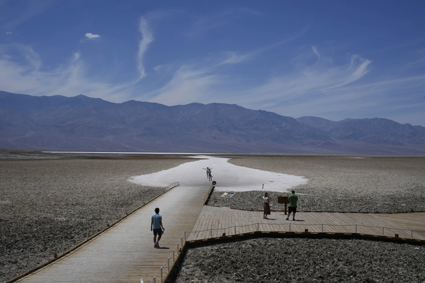Du khách đi bộ dọc theo lối lát ván để đến bãi muối ở Badwater Basin hôm 16/7. (Ảnh: AP)
