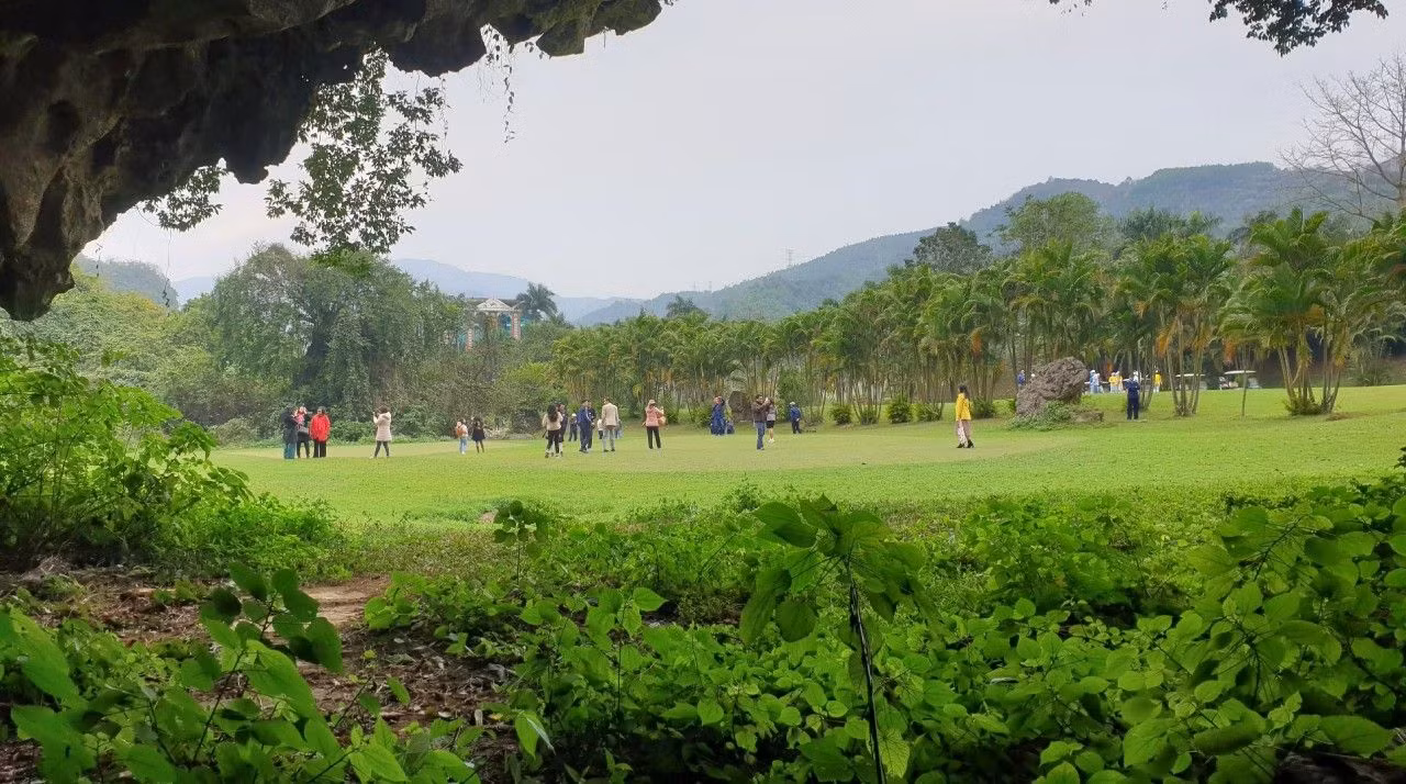 Hang Nhà báo nằm dưới chân một núi đá vôi. Trước cửa hang ngày nay là một bãi cỏ xanh mướt. (Ảnh: THU TRANG)