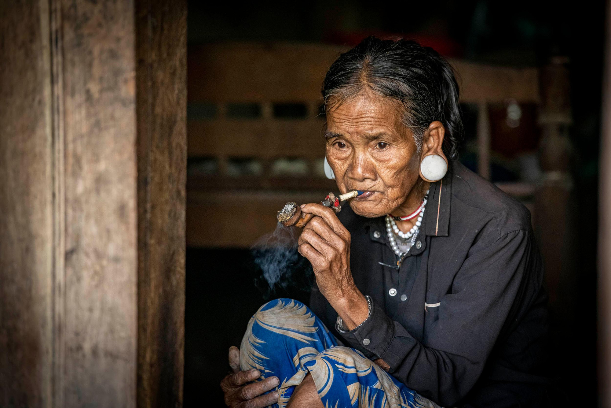 Người già Brâu vẫn giữ tục căng tai và hút thuốc bằng tẩu (Ảnh: THÀNH ĐẠT)