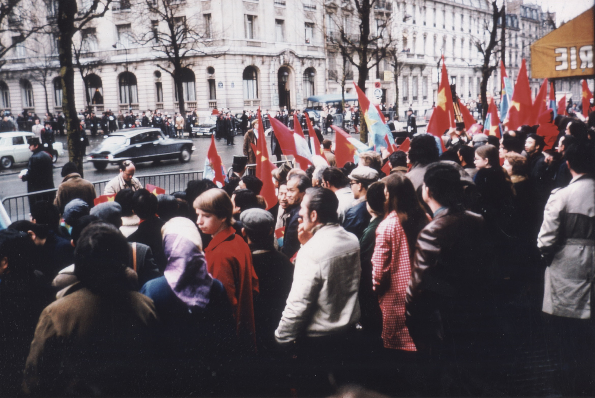 Đường phố gần Trung tâm Hội nghị quốc tế Kléber chật kín người vẫy cờ chào đón hai đoàn đám phán của Việt Nam. (Ảnh: Lê Xuân Tấn)