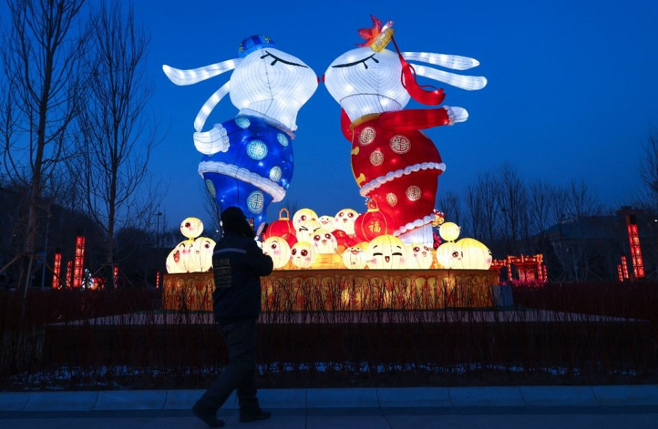 Người đi đường ngắm nhìn đèn lồng mang hình dáng của những chú thỏ tại tỉnh Liêu Ninh, đông bắc Trung Quốc. Trong thông điệp năm mới, Chủ tịch Tập Cận Bình khẳng định Trung Quốc giờ đây bước vào giai đoạn chống dịch mới, dù thử thách vẫn còn đó nhưng cũng có những tia hy vọng, đồng thời kêu gọi mọi người cùng đoàn kết, nỗ lực hơn nữa trong năm mới. Ảnh: AFP/STR)