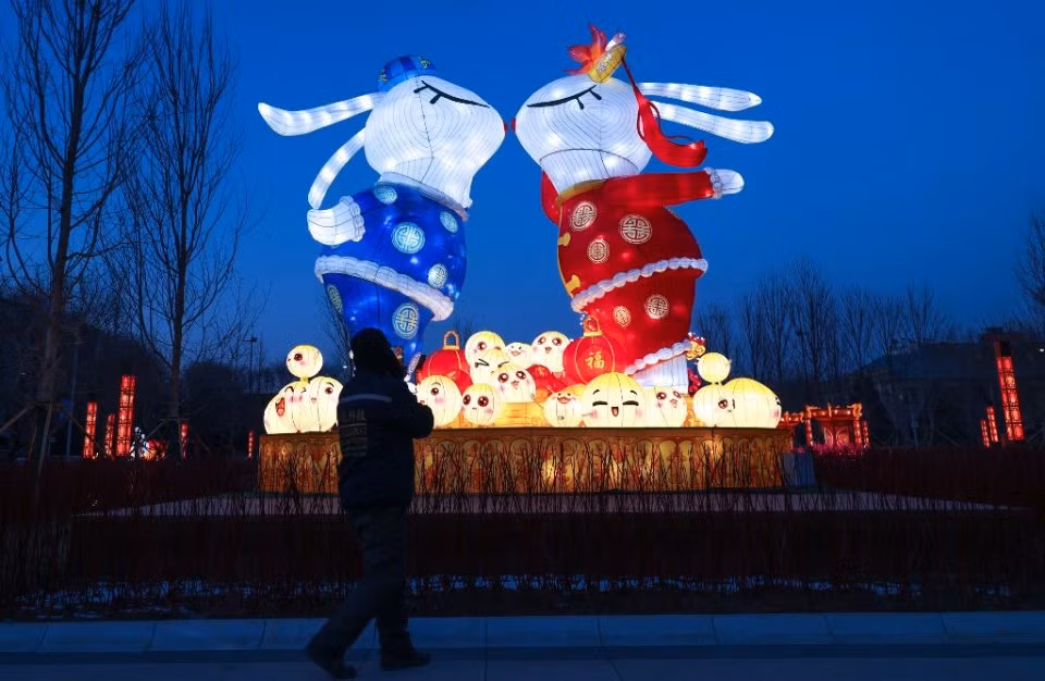 Người đi đường ngắm nhìn đèn lồng mang hình dáng của những chú thỏ tại tỉnh Liêu Ninh, đông bắc Trung Quốc. Trong thông điệp năm mới, Chủ tịch Tập Cận Bình khẳng định Trung Quốc giờ đây bước vào giai đoạn chống dịch mới, dù thử thách vẫn còn đó nhưng cũng có những tia hy vọng, đồng thời kêu gọi mọi người cùng đoàn kết, nỗ lực hơn nữa trong năm mới. Ảnh: AFP/STR)