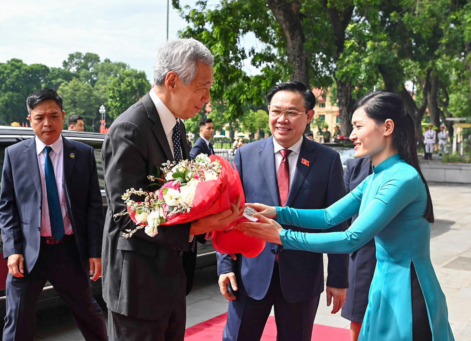 Lễ tân Văn phòng Quốc hội tặng hoa chào mừng Thủ tướng Singapore.