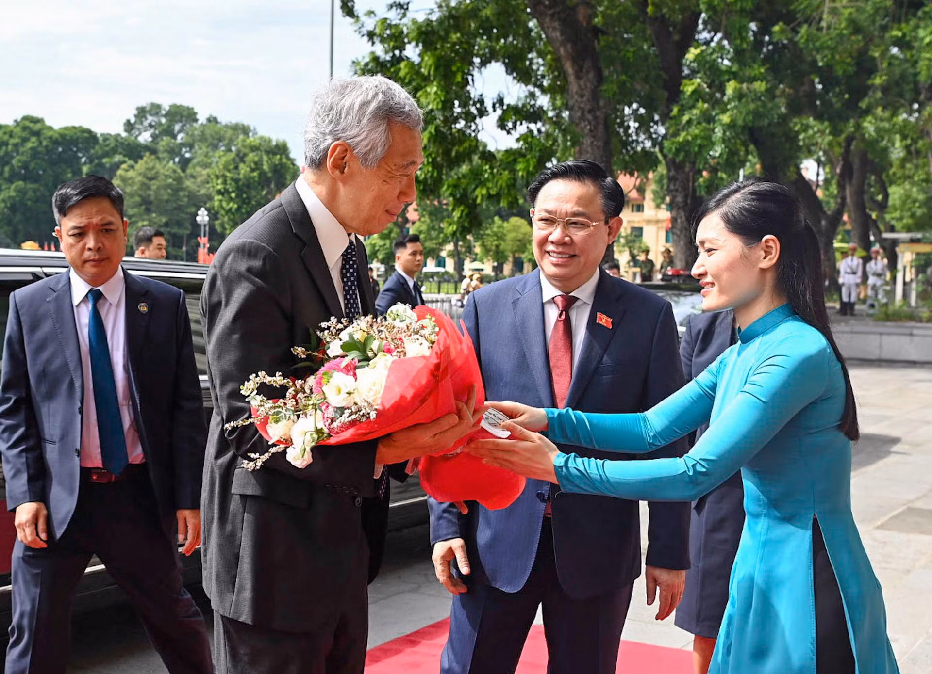 Lễ tân Văn phòng Quốc hội tặng hoa chào mừng Thủ tướng Singapore.