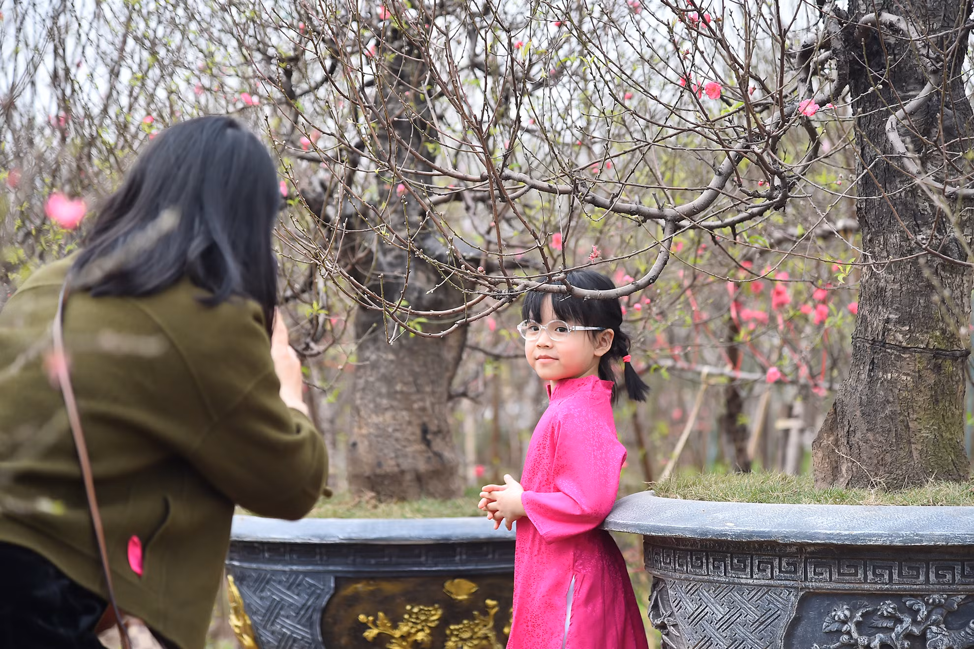 Nhiều bạn nhỏ được gia đình đưa đến các vườn đào để tham quan, lưu giữ những khoảnh khắc đẹp để đón chào năm mới.